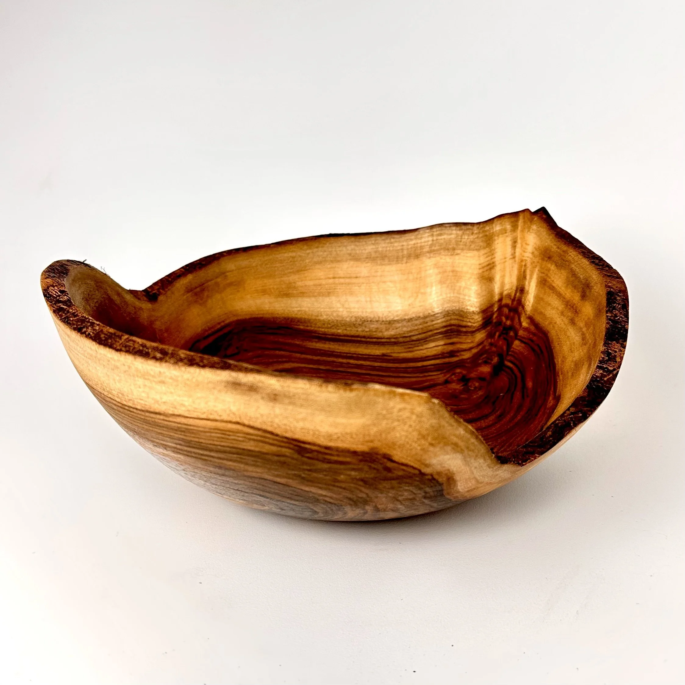 Wooden English walnut bowl with natural grain pattern and smooth natural live edge. 