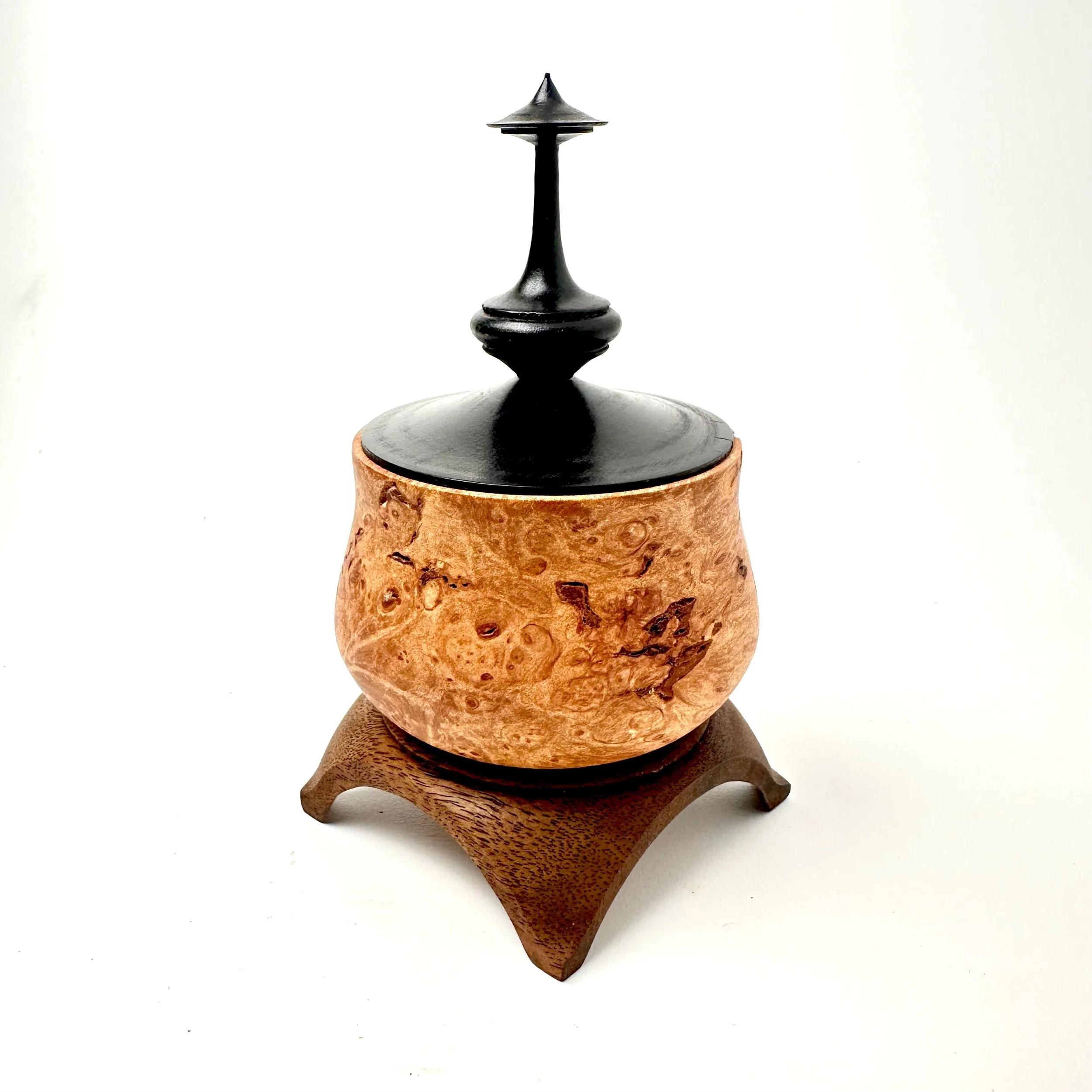 A decorative vessel featuring maple burl, walnut, madrone and gemstone inlays. 