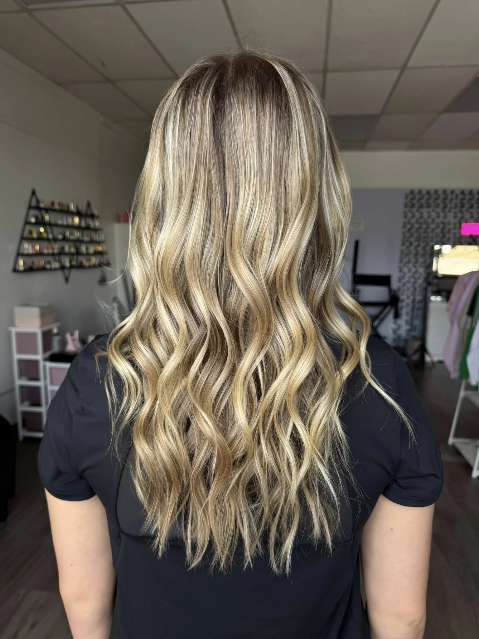 Back view of a woman with long, wavy blonde hair.