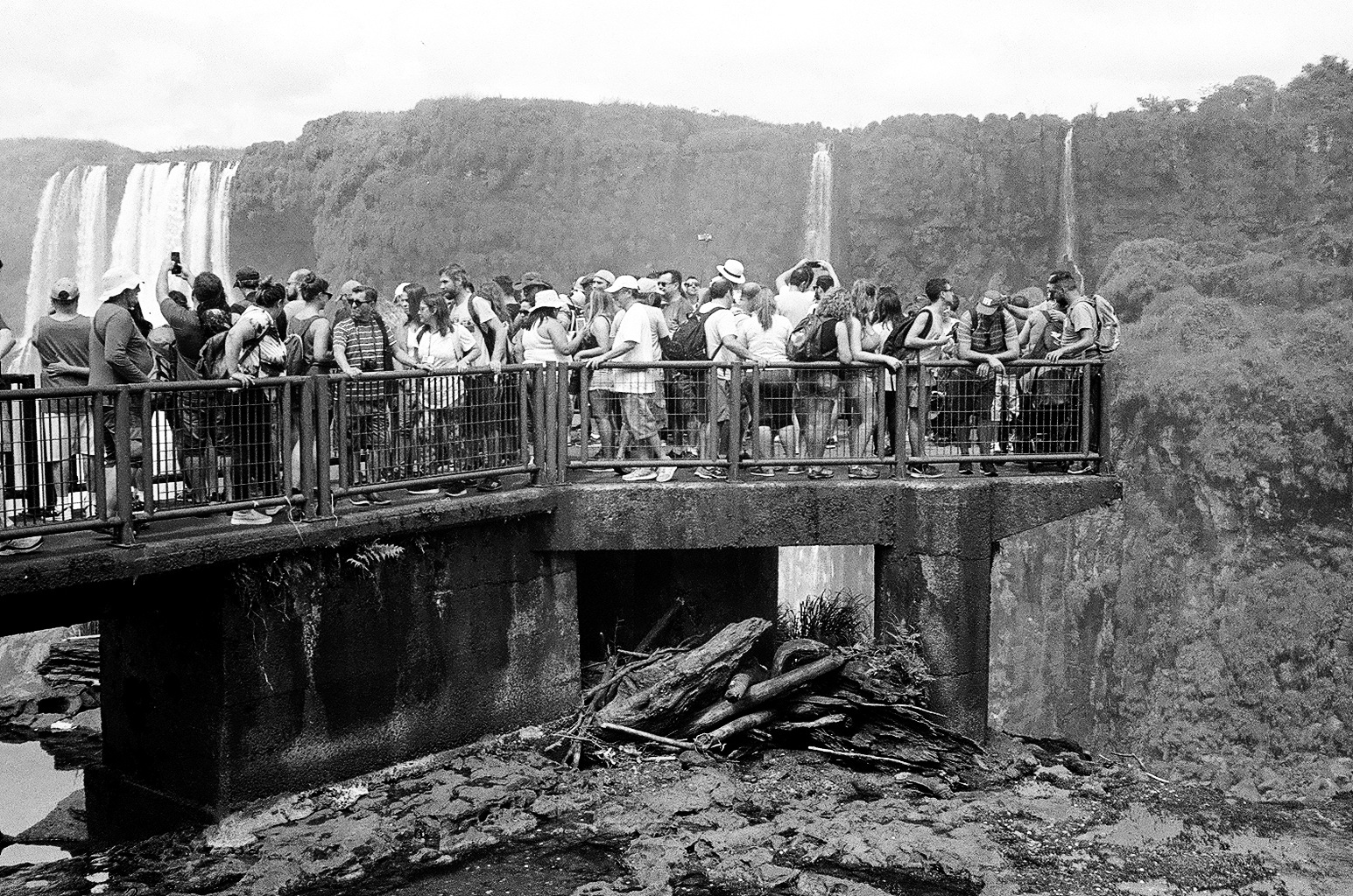Grupo de pessoas em uma ponte de observação em frente às Cataratas do Iguaçu