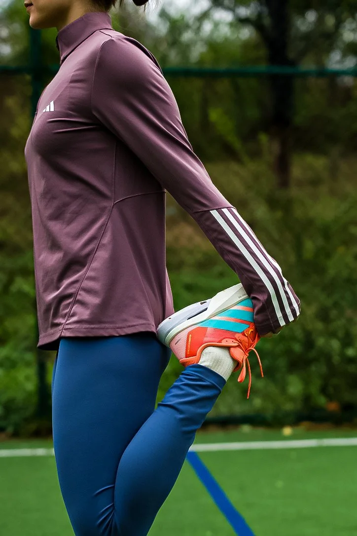 Person in athletic wear stretching on a sports field