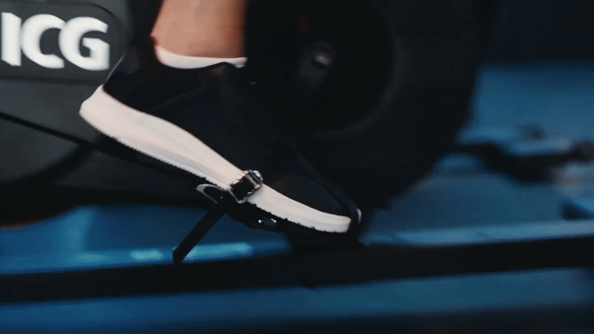 Close-up of a person wearing a black and white sneaker on a black treadmill, with the 'ICG' logo visible.