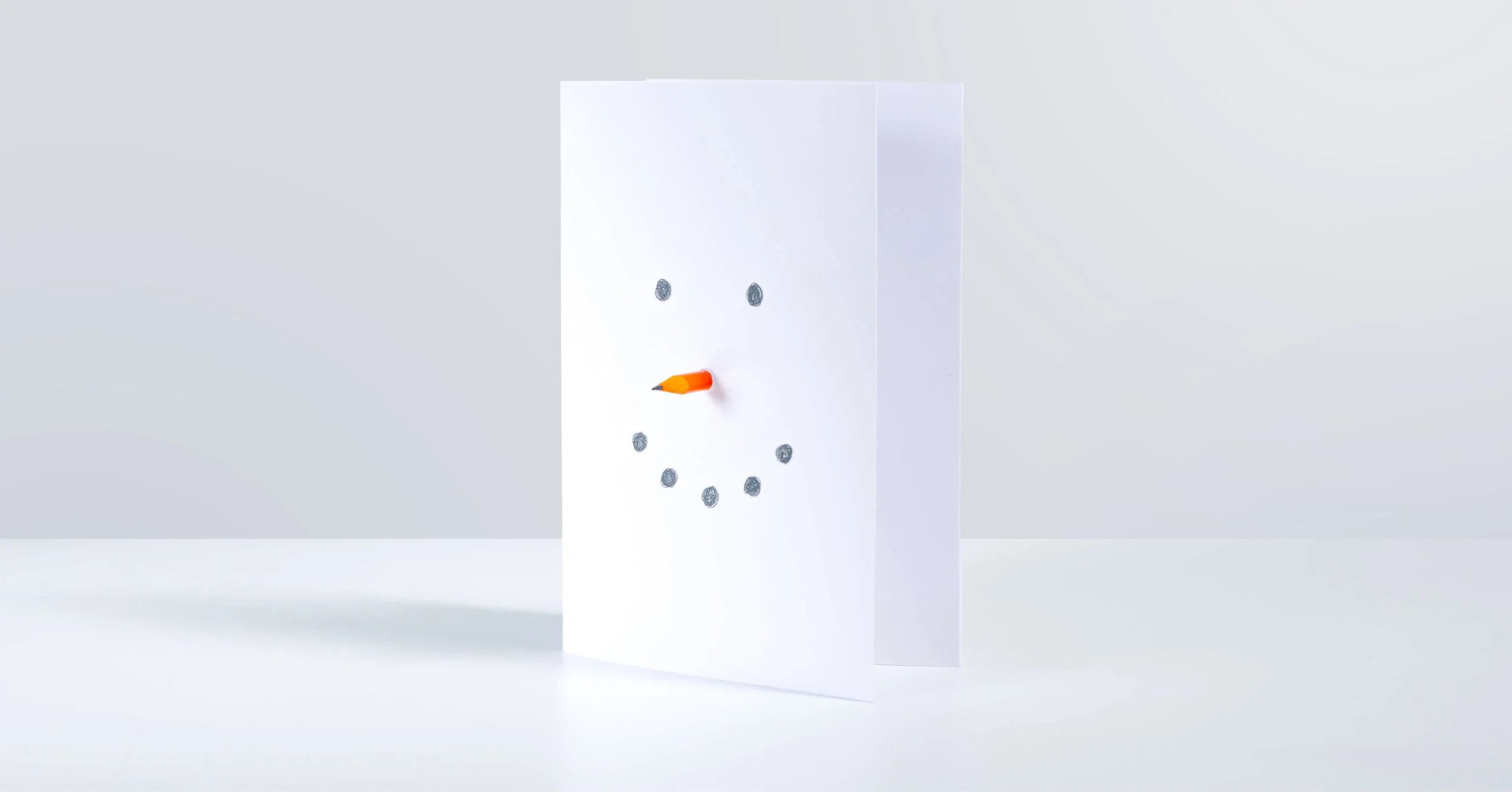 White paper with clock face design, features a pencil as the hour hand, with small circles marking the hours.