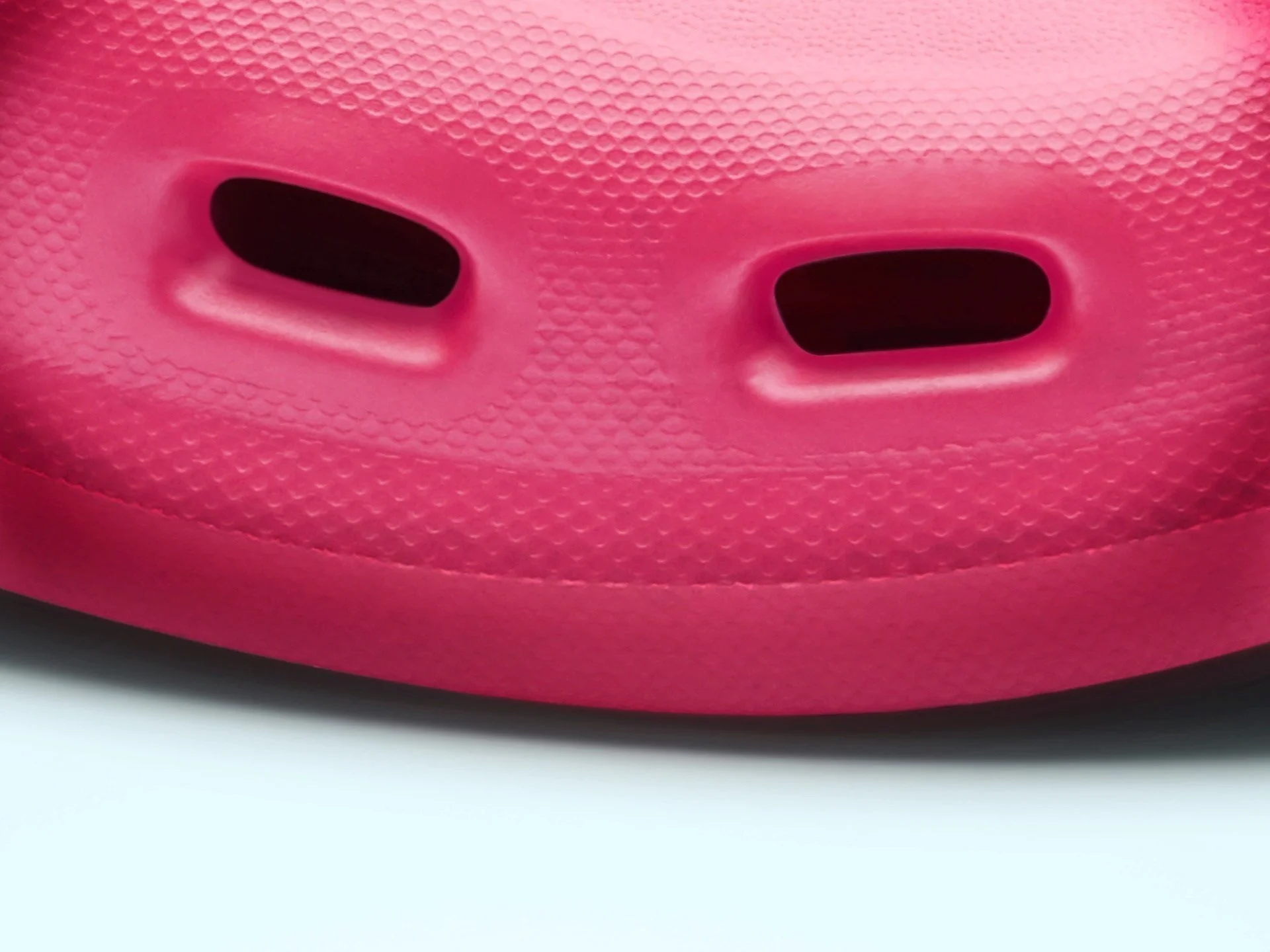 Close-up of a pink facial mask with eye openings.