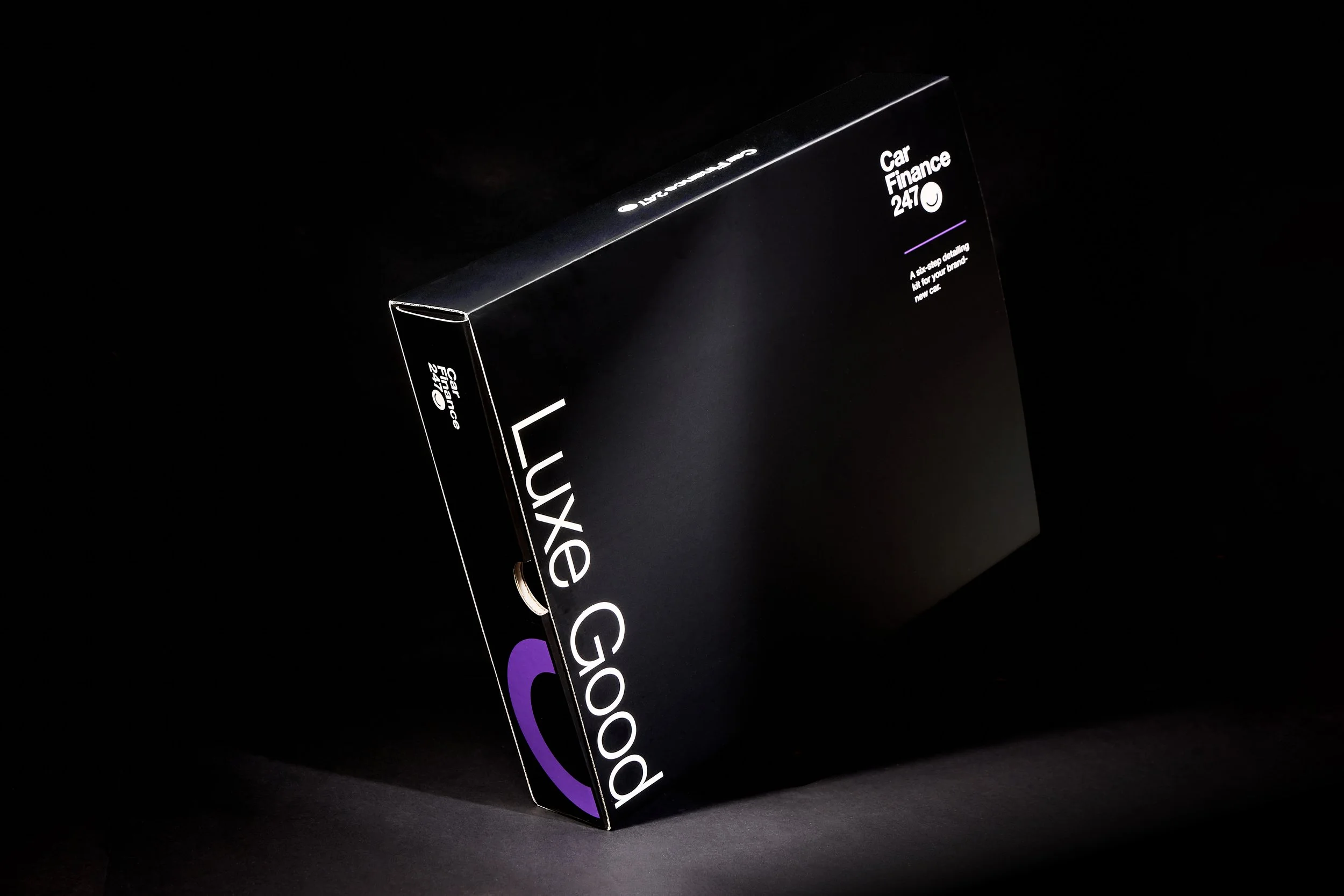 Black box with white and purple text that reads "Luxe Good" and "Car Finance 24/7" on a dark background.