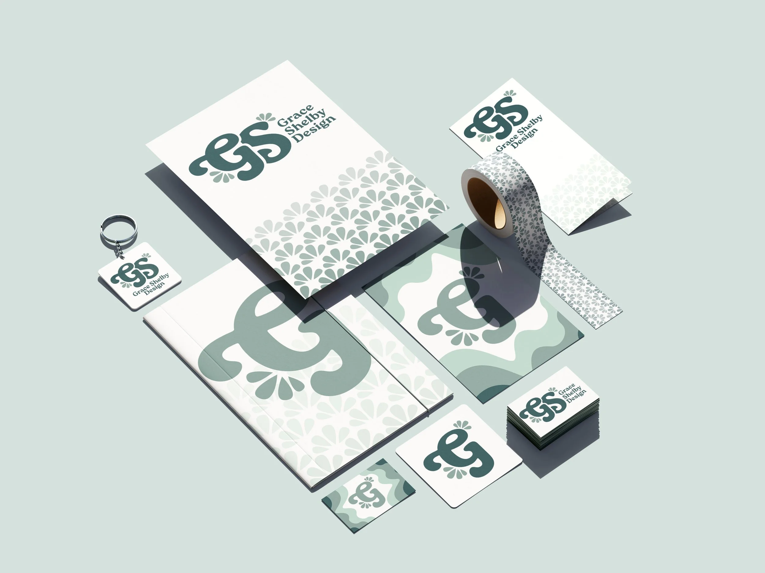 Branding and packaging materials for Grace Shelby Design, including business cards, letterhead, sticky notes, keychain, and tape, all featuring a consistent logo and design pattern.