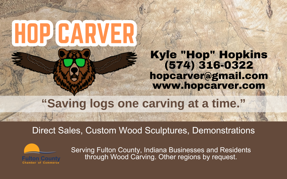 Business card for Hop Carver, a wood carving business. Features a bear with sunglasses, contact info, and slogan 'Saving logs one carving at a time.' Also includes logos for Fulton County Chamber of Commerce and a website.
