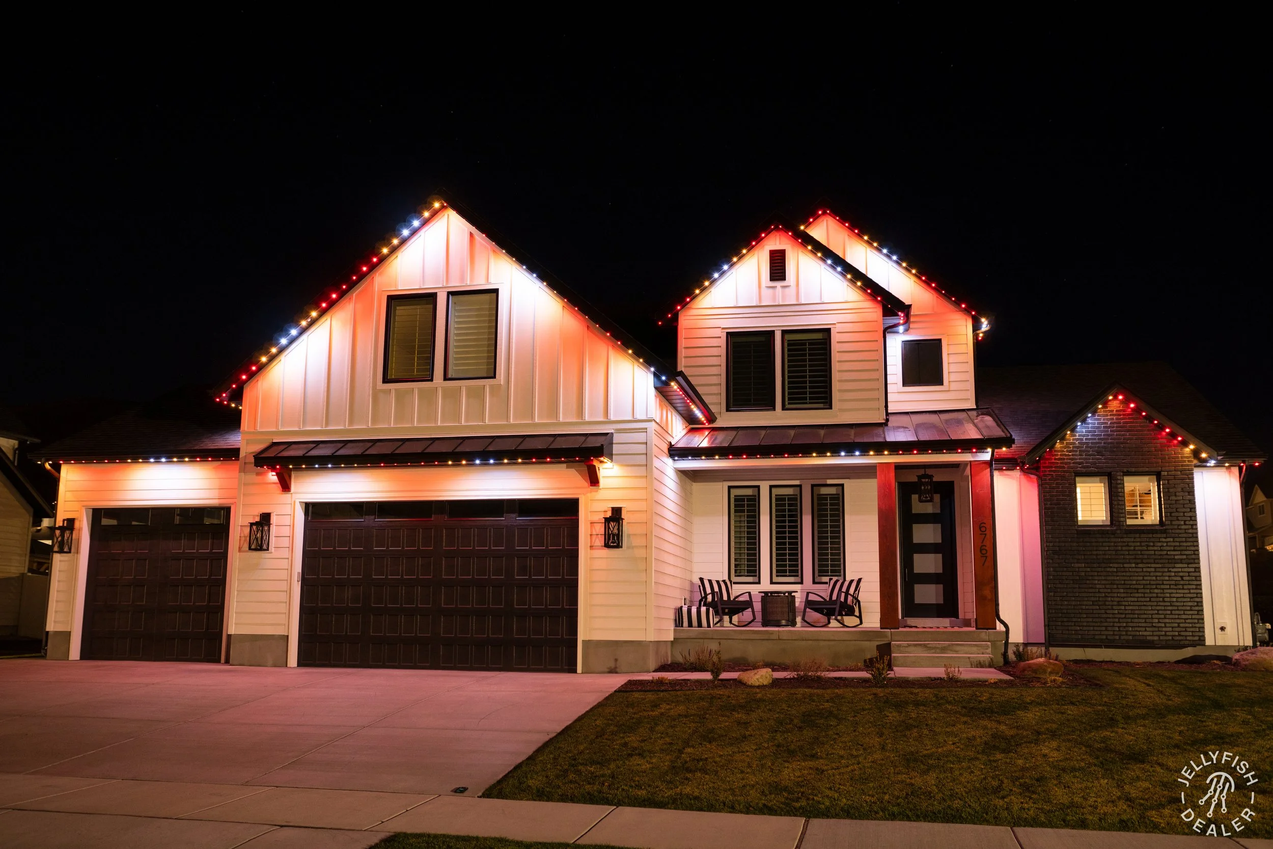 Architectural accent lighting highlighting multi-car garages, entryways, and upper rooflines.