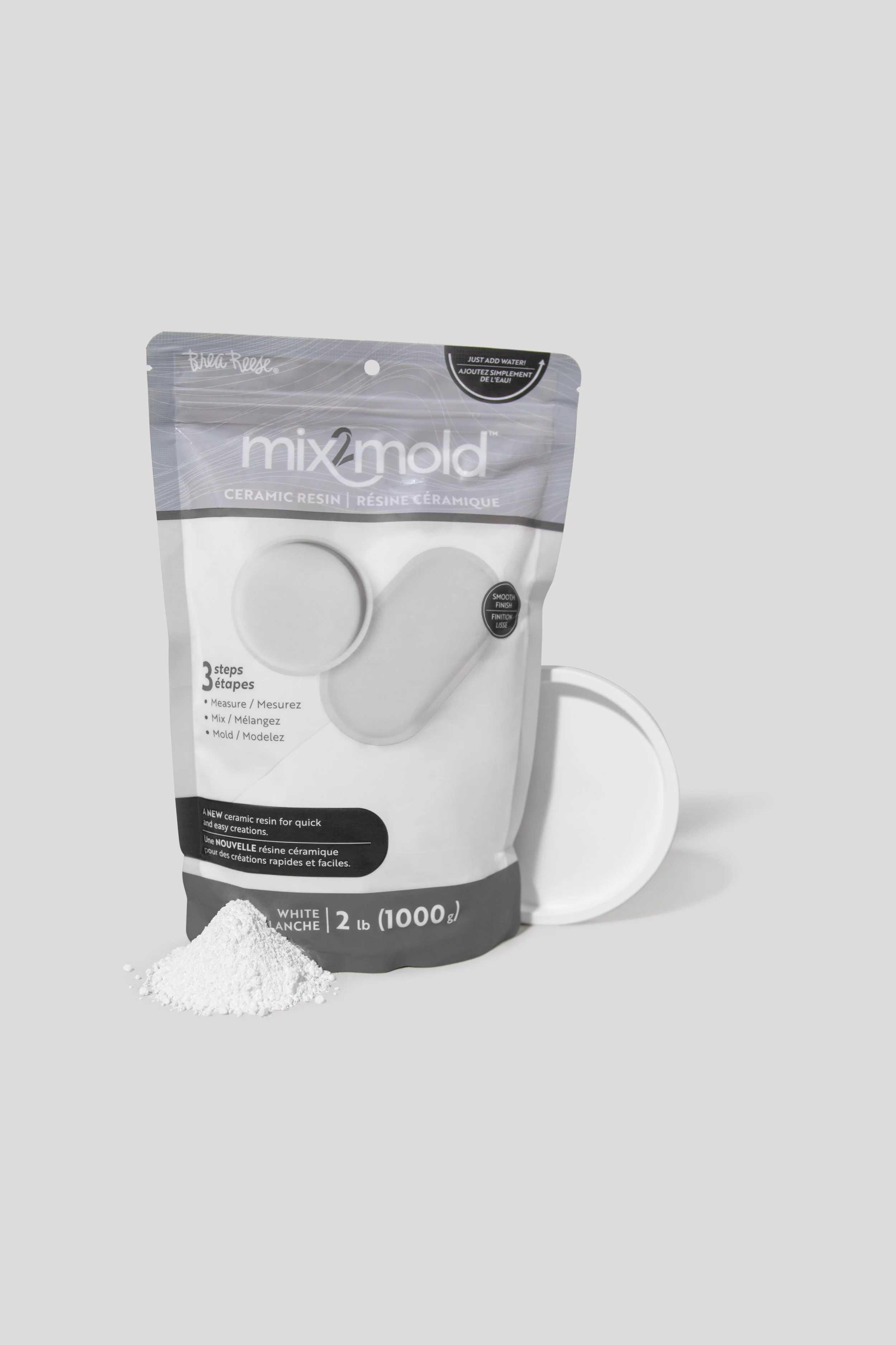 A bag of Mix2Mold ceramic resin with a small pile of white powder in front and a white mold piece leaning against the bag, set against a plain gray background.