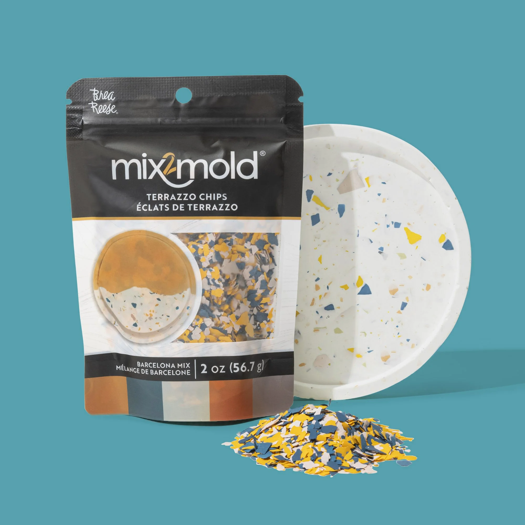 A bag of Mixomold terrazzo chips beside a terrazzo-style paper plate and a small pile of colorful broken terrazzo chips on a teal background.