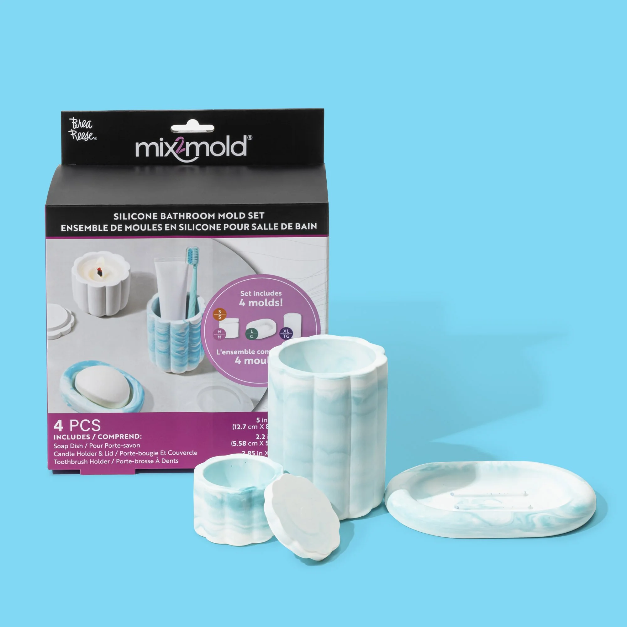 Set of four silicone bathroom molds including a soap dish, candle holder, and toothbrush holder, with packaging seen in the background on a light blue surface.