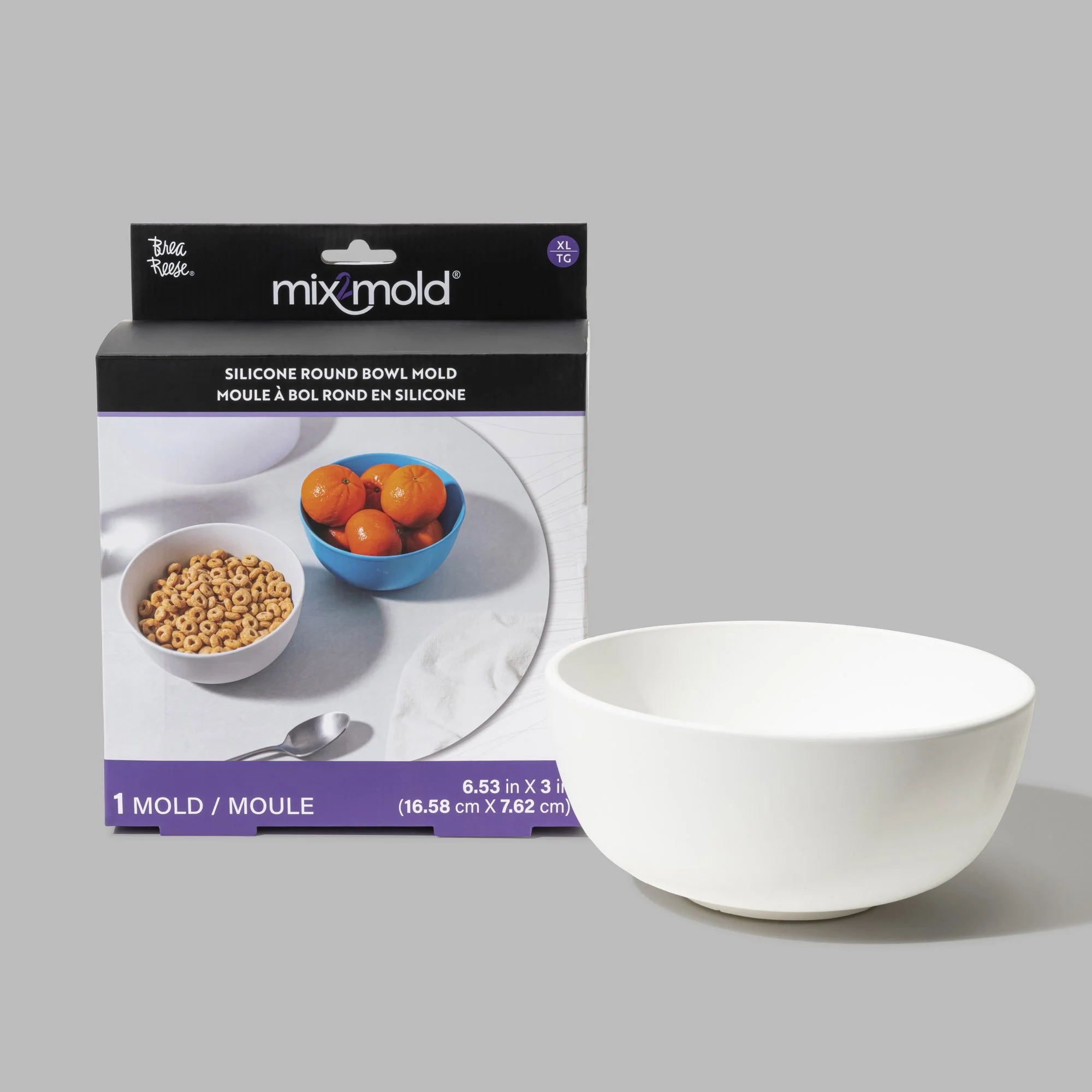 A white silicone round bowl placed next to its packaging box. The box shows an image of the bowl filled with oranges and cereal.