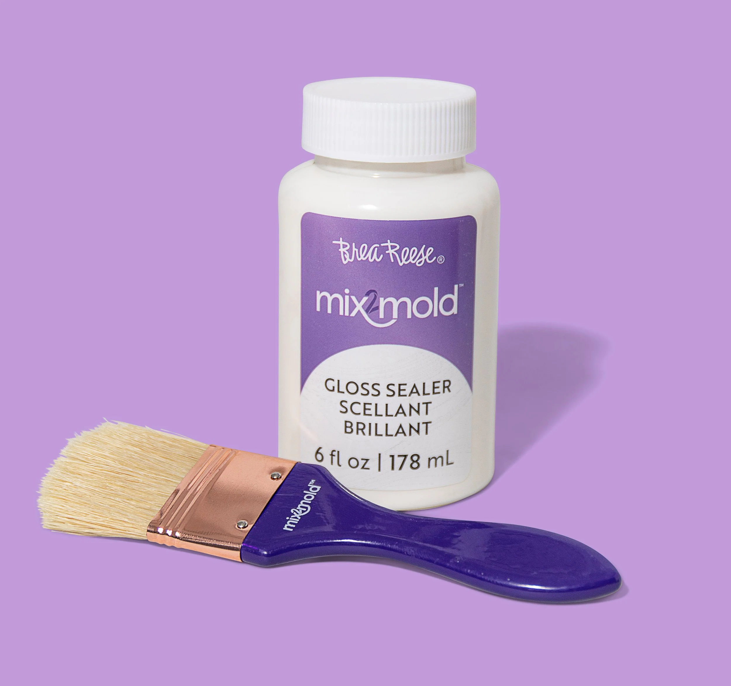 Bottle of BreaReese Mix2Mold gloss sealer and a paintbrush on a purple background.