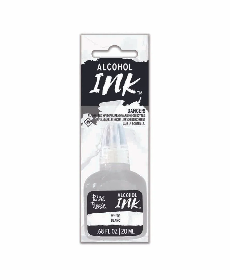 Packaging of alcohol ink in a small bottle with a black and white label, featuring the words 'Alcohol Ink,' the brand 'Brea Reese,' and the color 'White,' with an alcohol warning and hazard symbols.