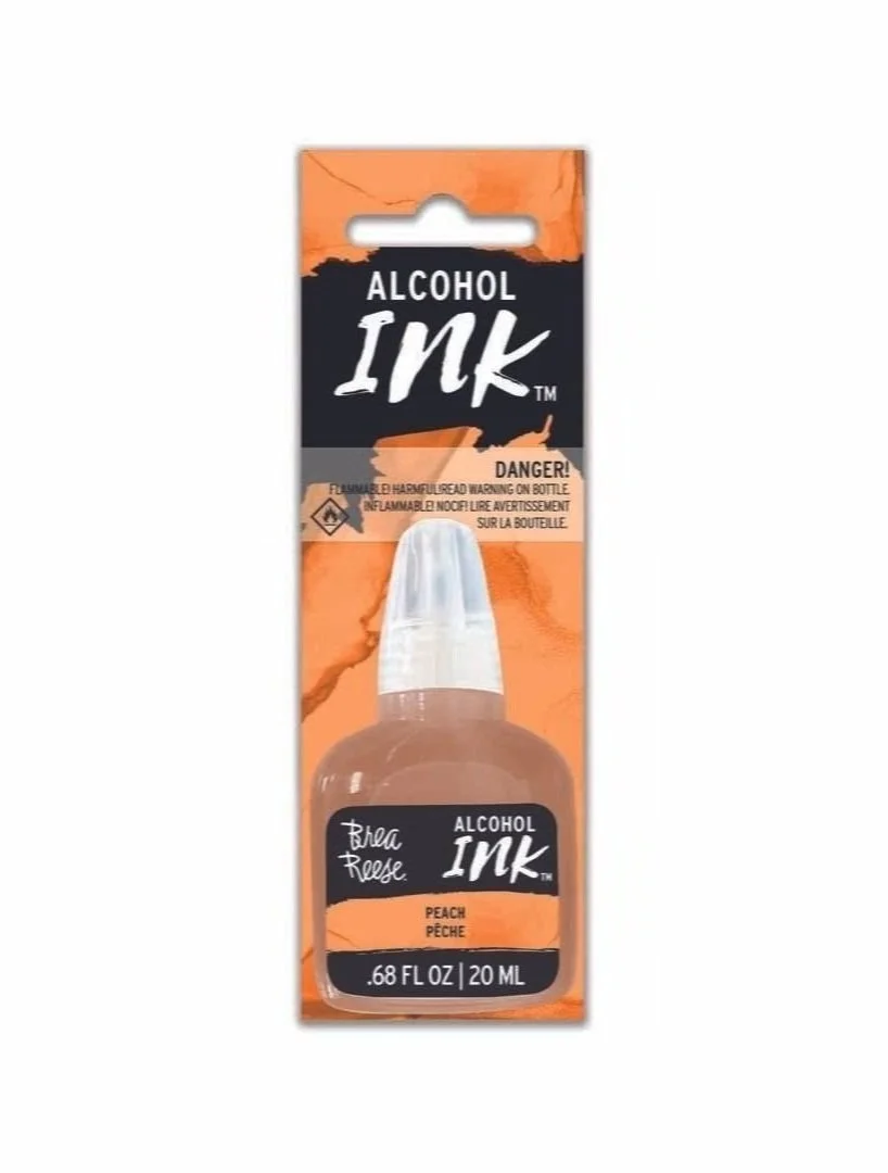 Peach-colored alcohol ink bottle with black label, white cap, packaging with black and orange design, warning label, and product details.