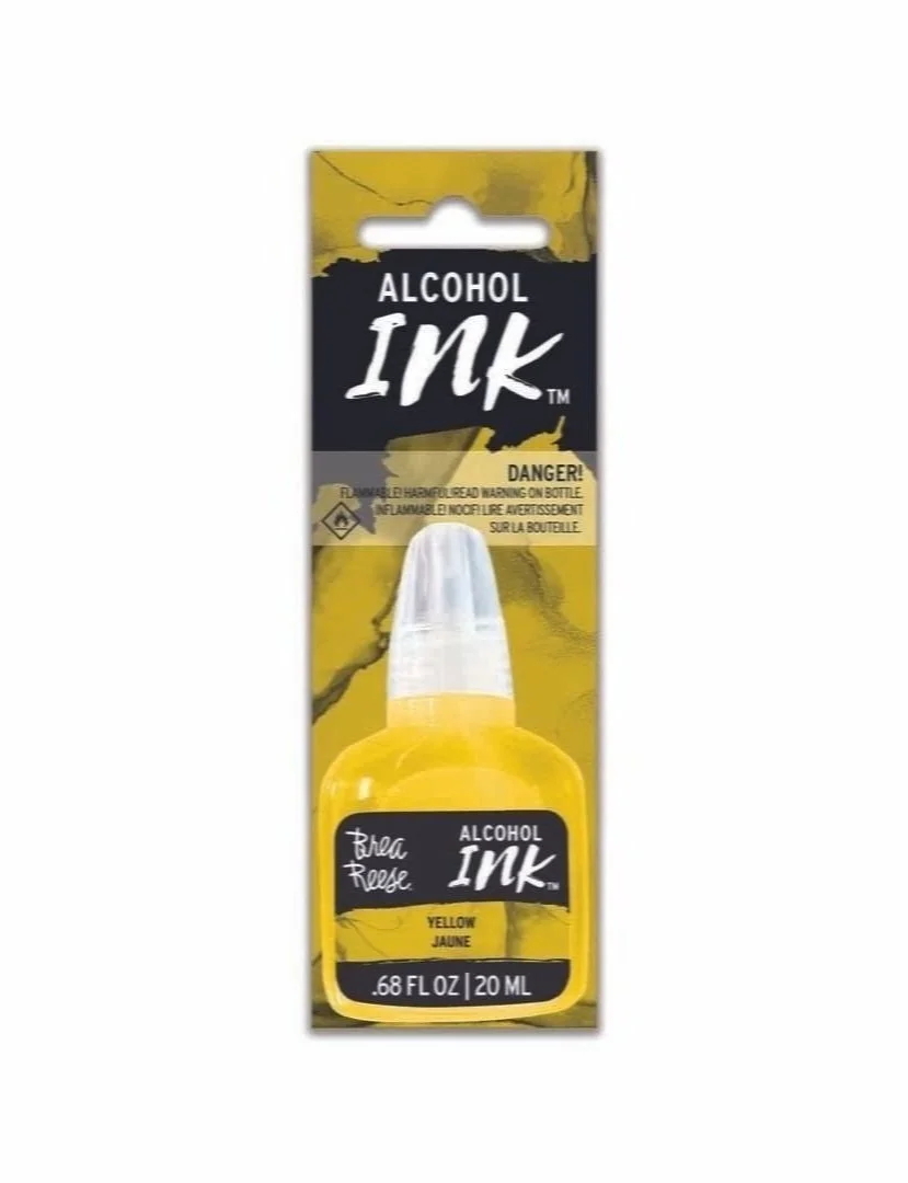 Yellow bottle of alcohol ink with a white cap and label, packaged in a cardboard backing with warning labels.