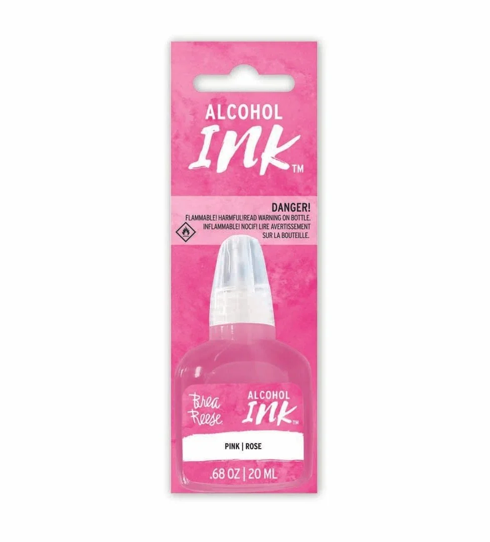 Packaging for alcohol ink in pink rose shade by Brea Reese, with a warning label about flammability, featuring a pink background and a clear bottle with a pink label.