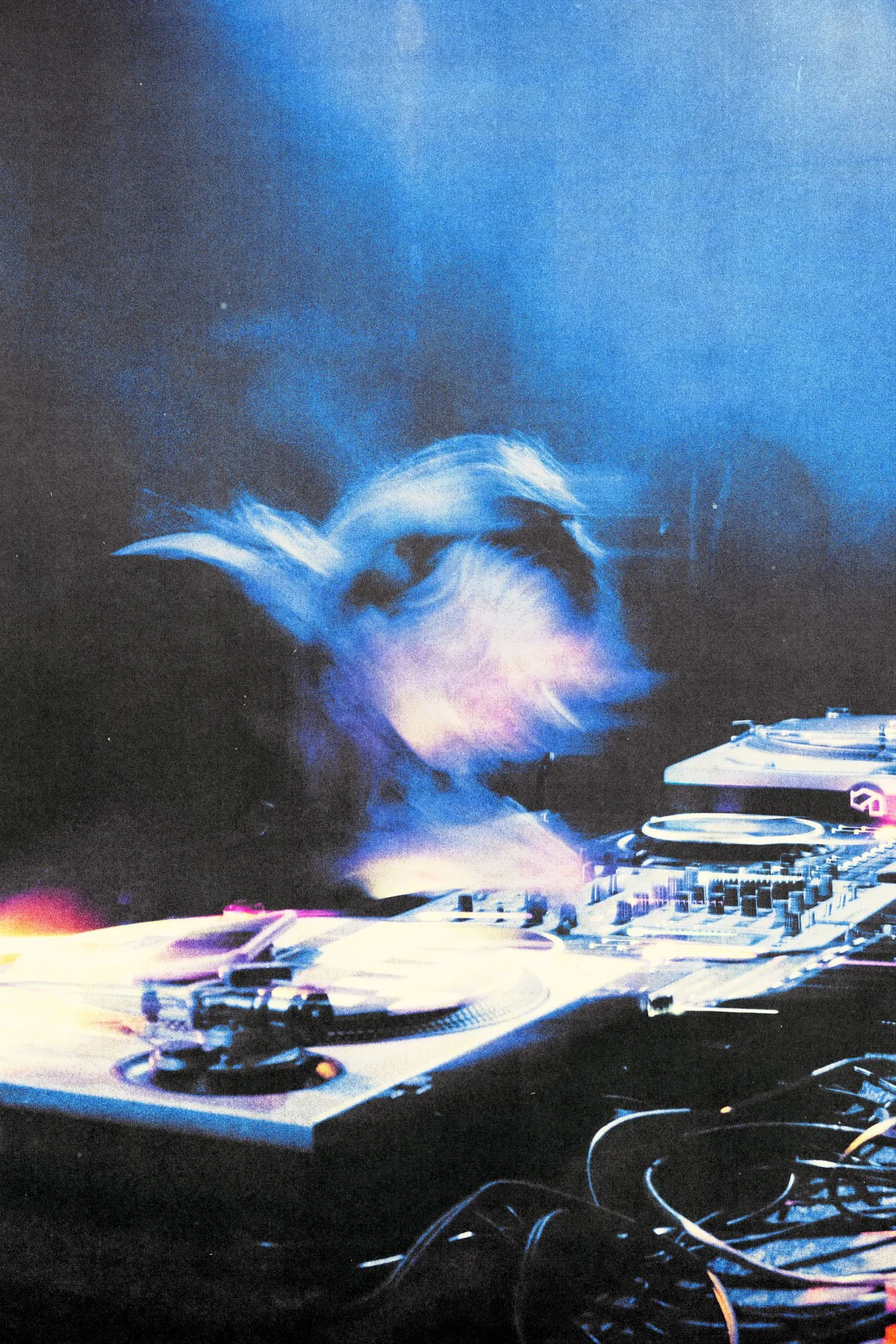 Un DJ mixe de la musique dans une ambiance lumineuse bleue et violette.