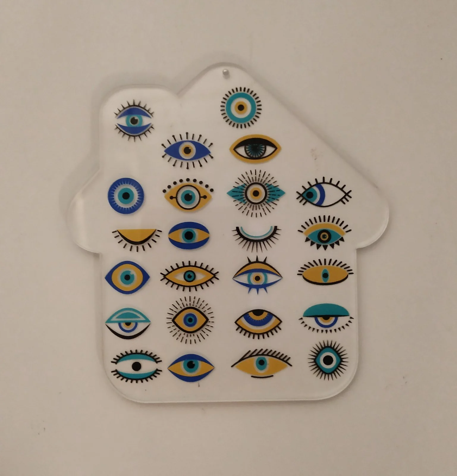 A clear plastic sheet with multiple stickers of stylized eyes in various colors and designs, arranged in an irregular pattern.