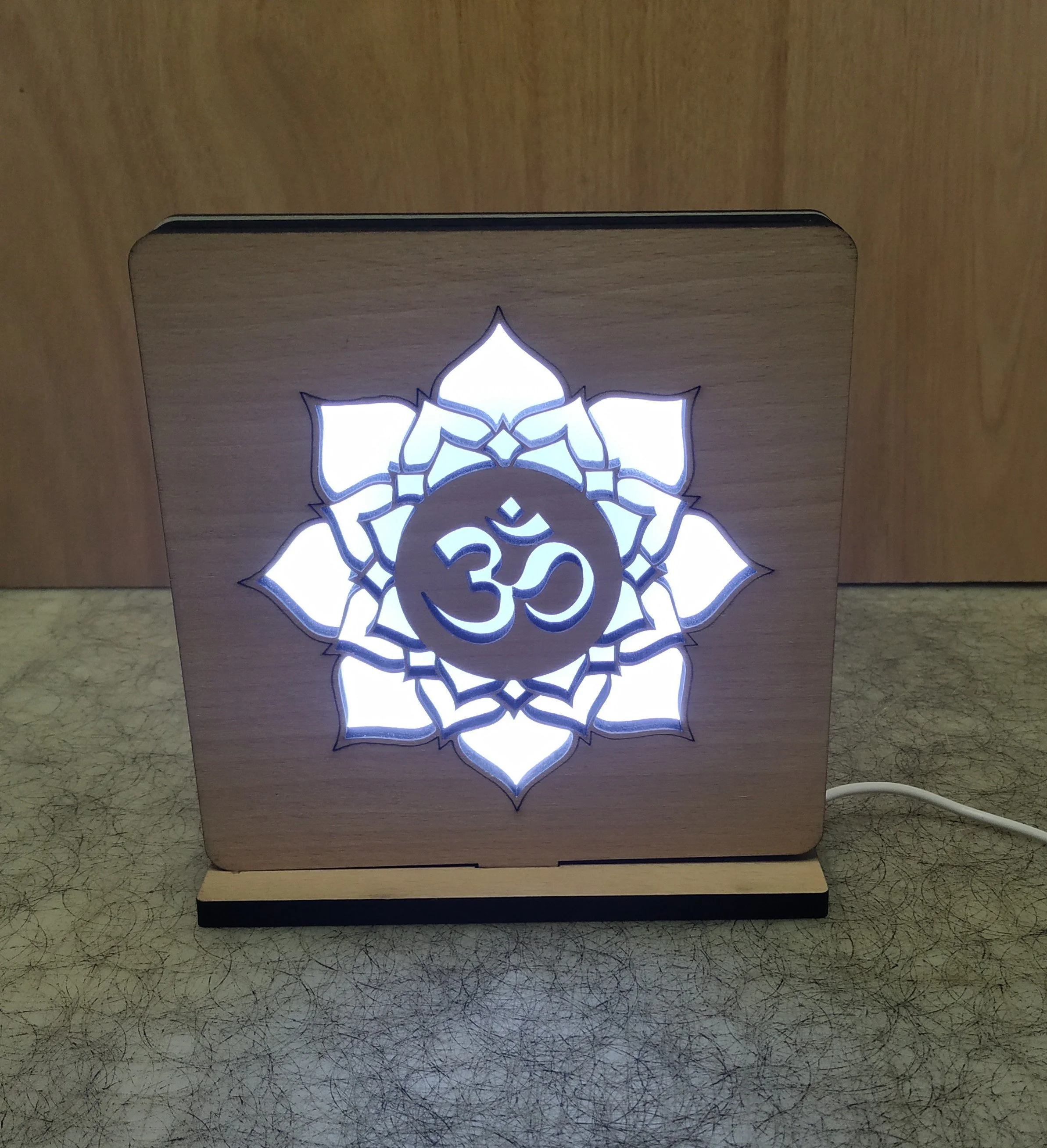 Decorative wooden lamp featuring a glowing Lotus flower design with the Om symbol in the center.