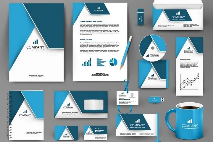 Collection of office branding materials and stationery, including notebooks, letterheads, business cards, a USB drive, a pen, a coffee mug, a CD, and various envelopes and documents, all featuring a blue and white color scheme with a company logo.