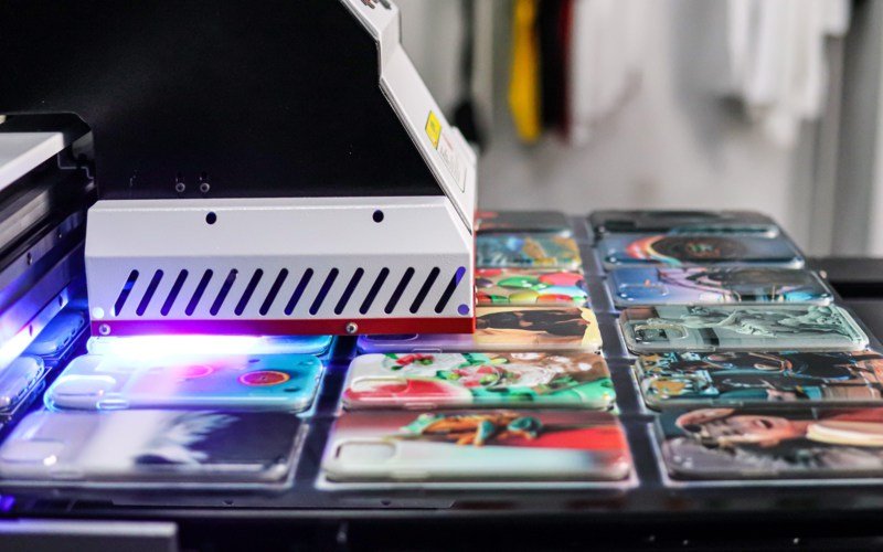 A UV printer printing colorful images on phone cases.