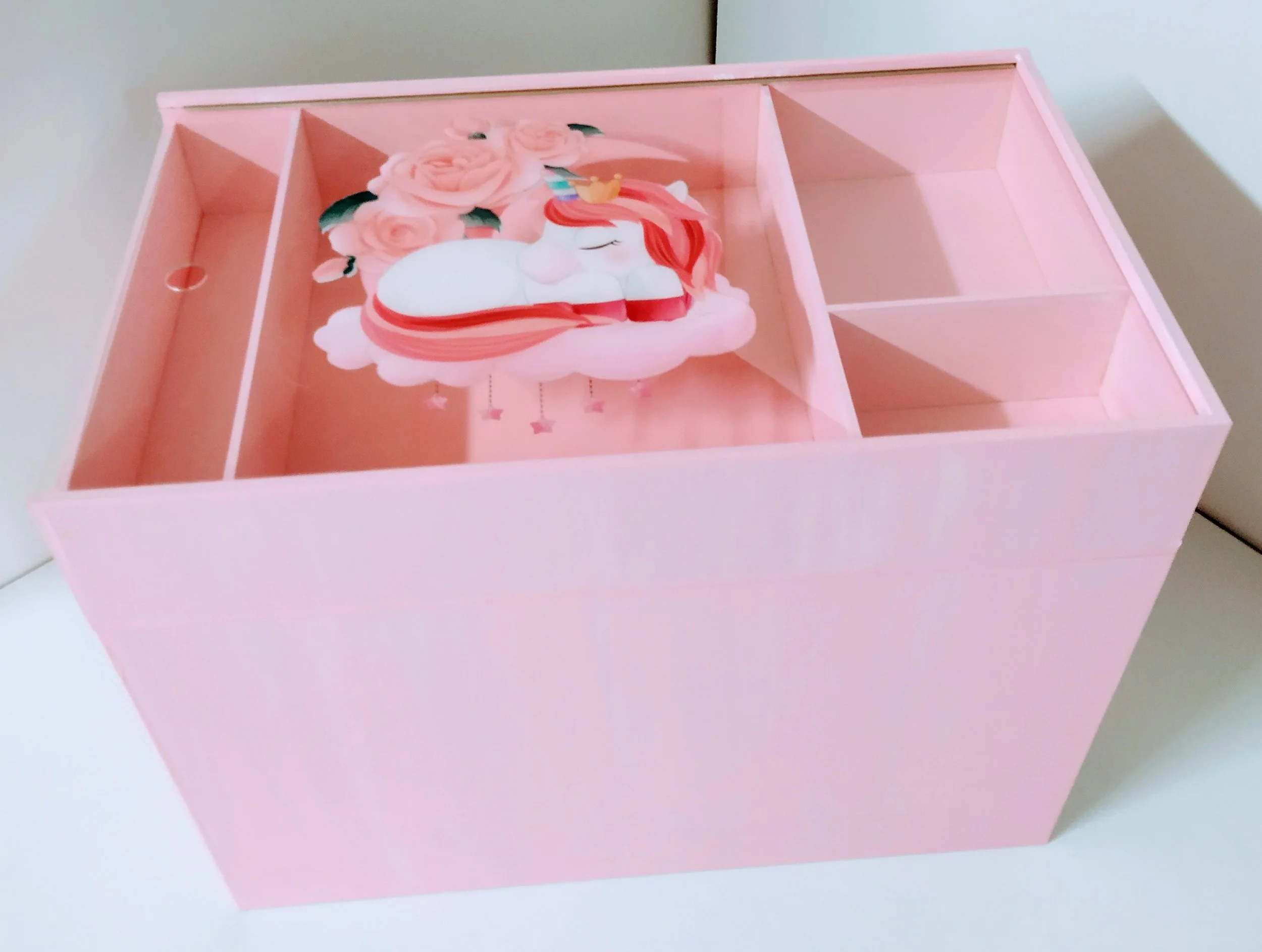 Pink jewelry or accessory box with a unicorn and rose design on the lid.