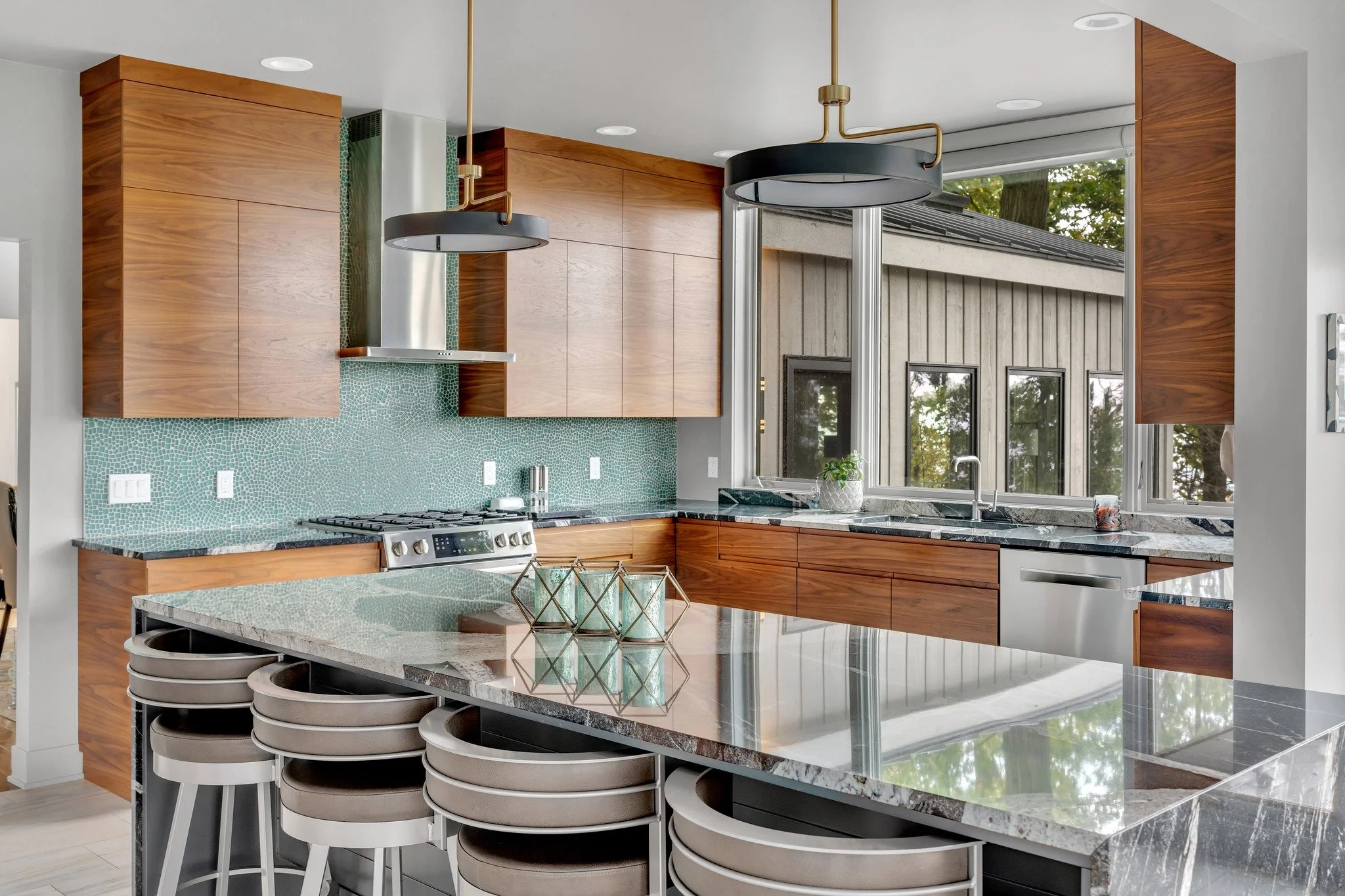 Between the waterfall countertop, minimal cabinets, and the blue backsplash, this kitchen has quickly become one of our favorites!