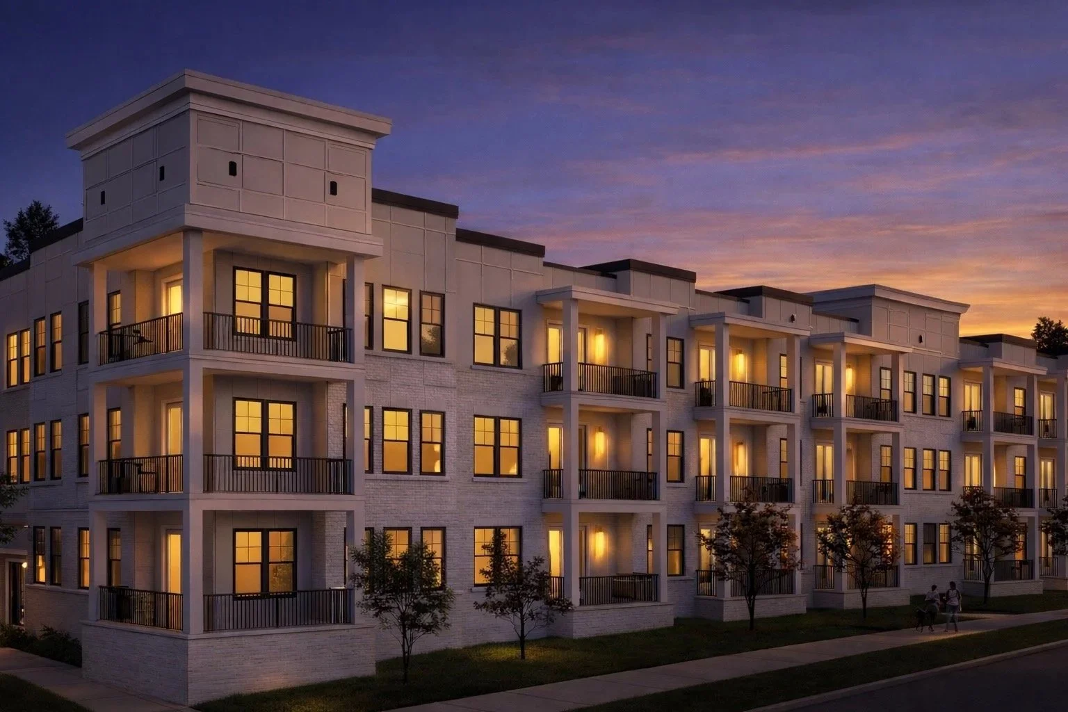 A multi-story apartment building with lit windows and balconies at sunset.