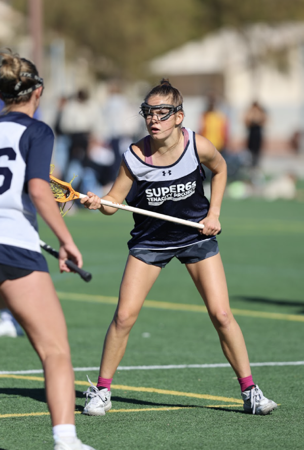 Girls lacrosse player with stick raised competing in the Tenacity Super 6s Fall Tournament in the Bay Area, California