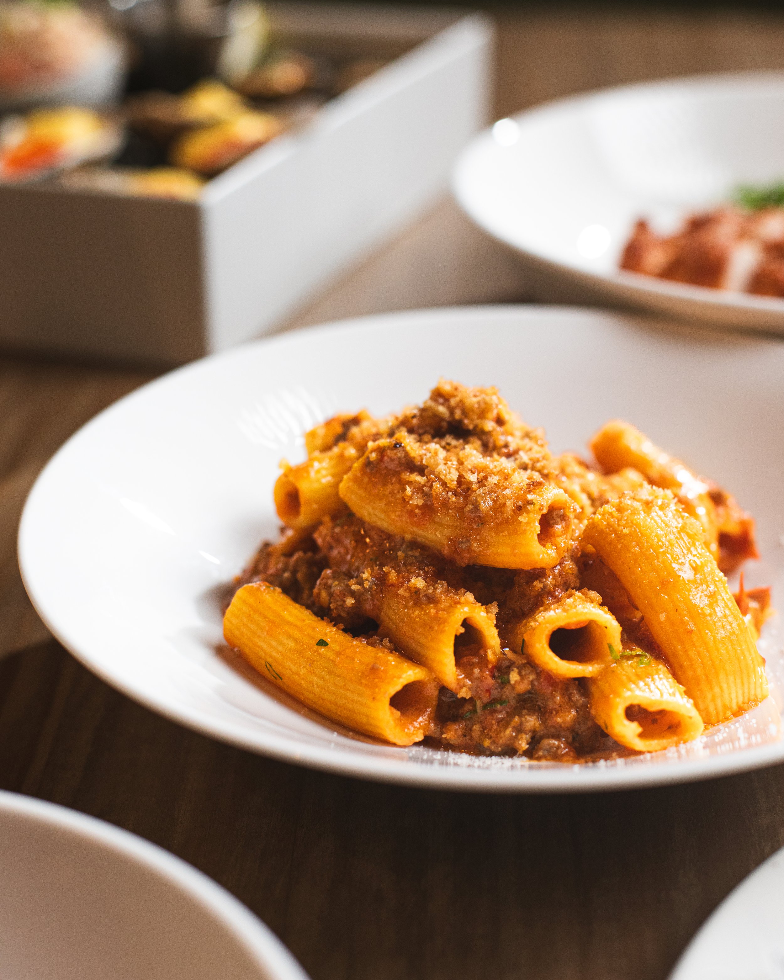 Cotto's Spicy Rigatoni features al dente pasta tossed in bold, slow-braised beef brisket ragu, finished with garlic breadcrumbs and optional stracciatella. Rich, comforting, and perfectly balanced with heat, it's a guest favorite.