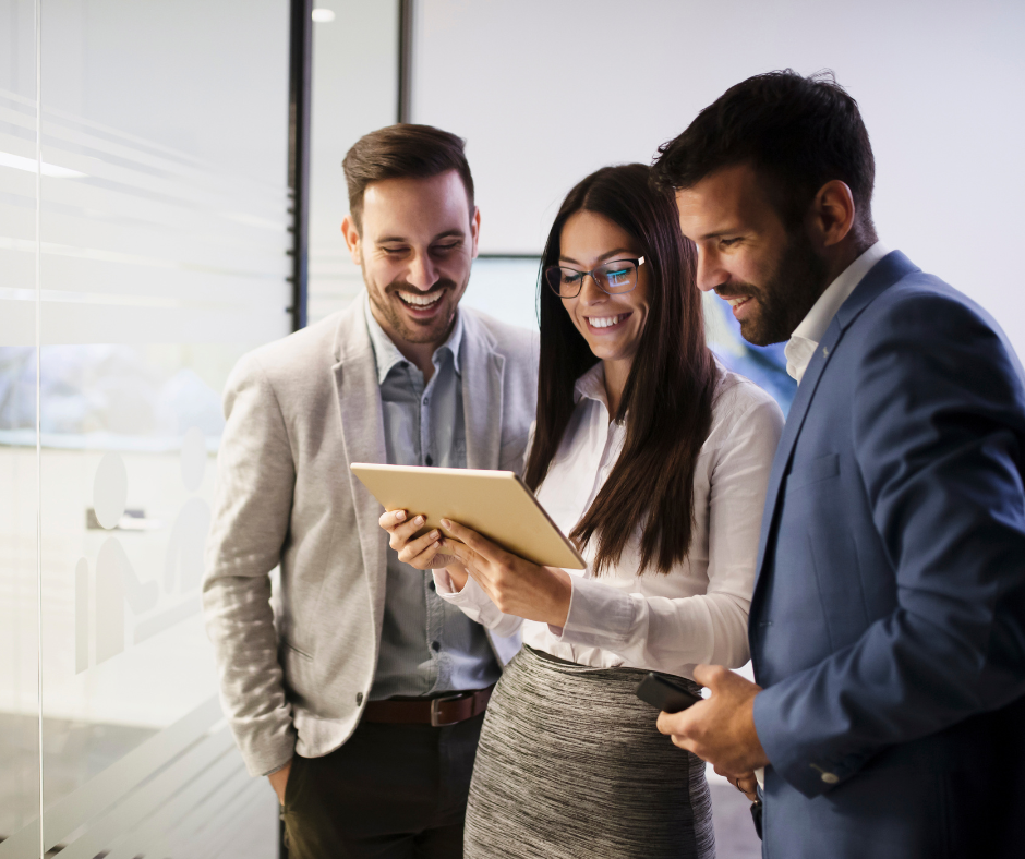 Group of work colleagues looking at a tablet and smiling