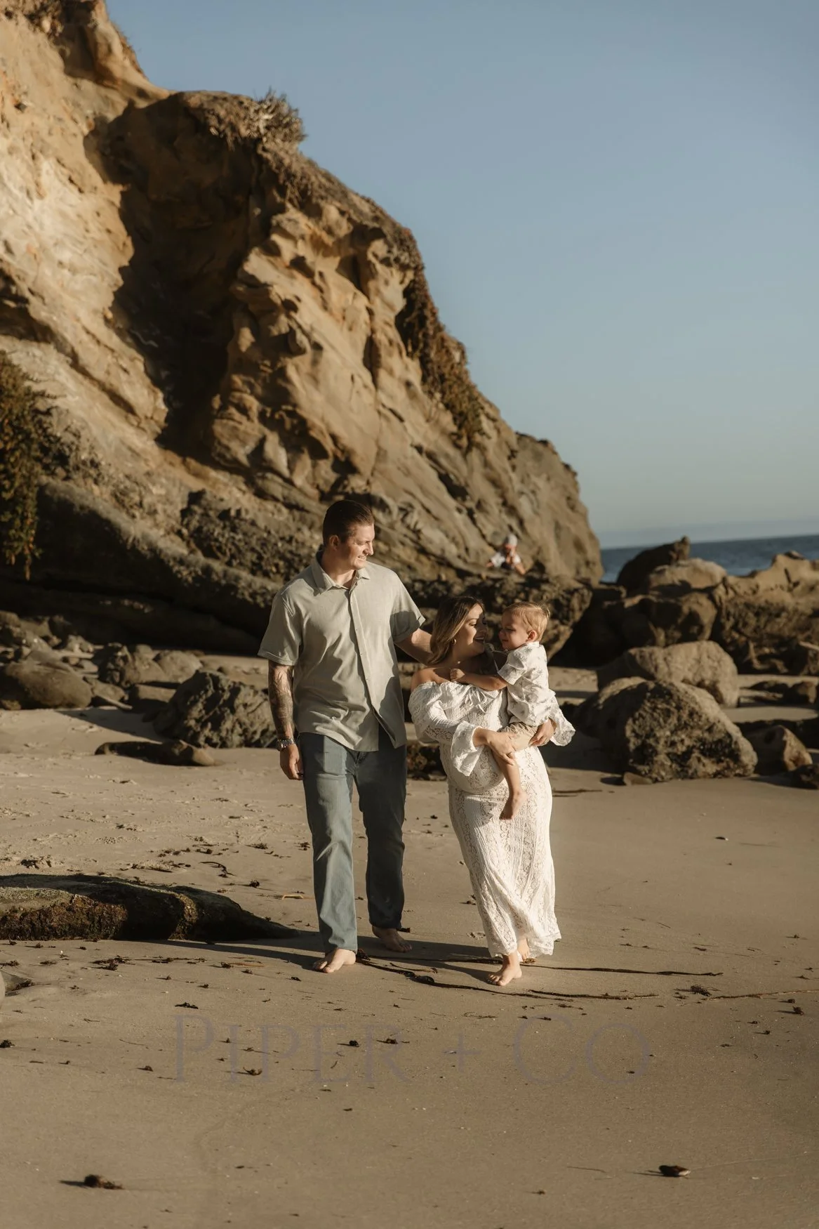 Los Angeles maternity photographer capturing a family with the expecting mother walking on a beach