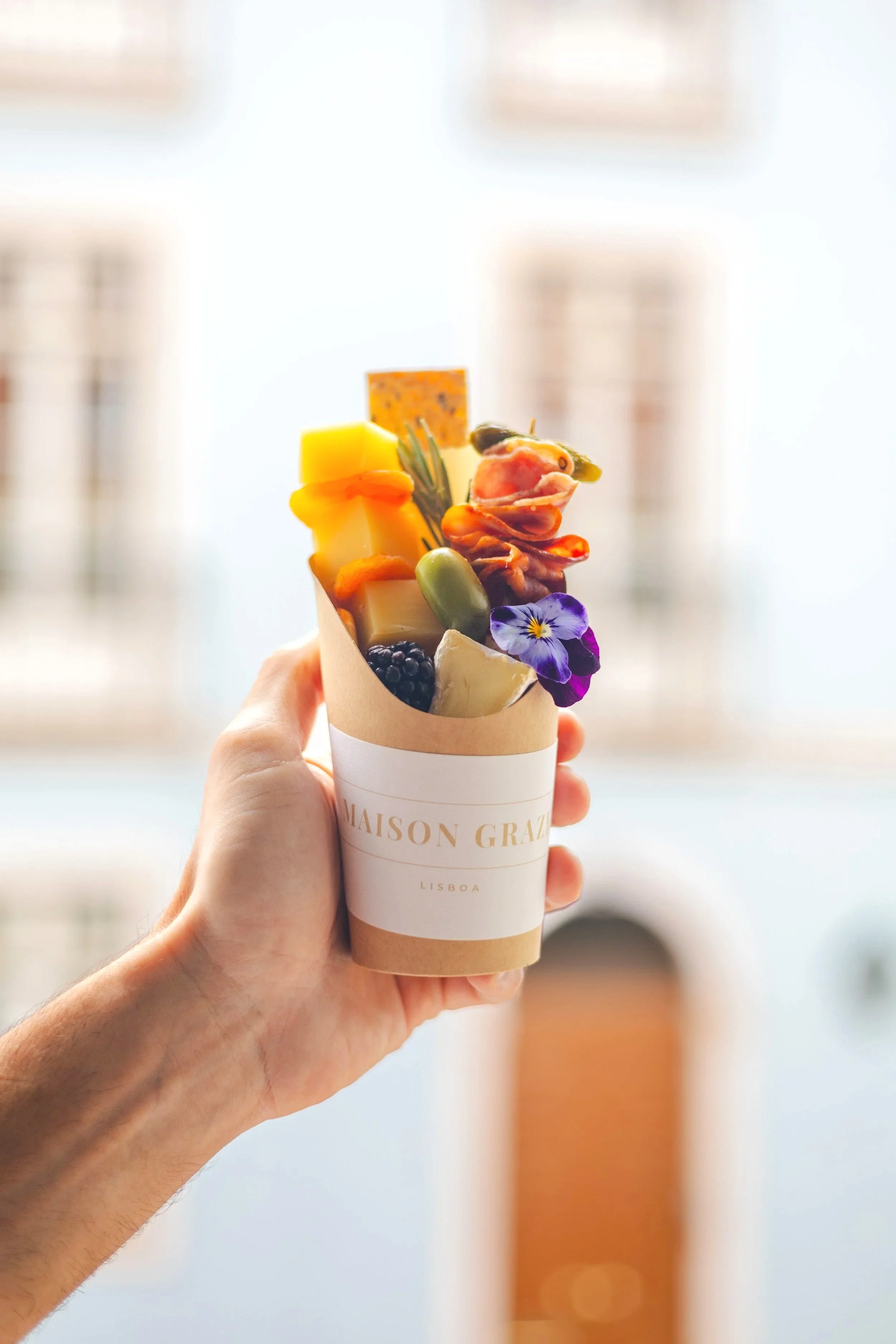 Grazing box featuring artisan cheeses, fruit and gourmet details