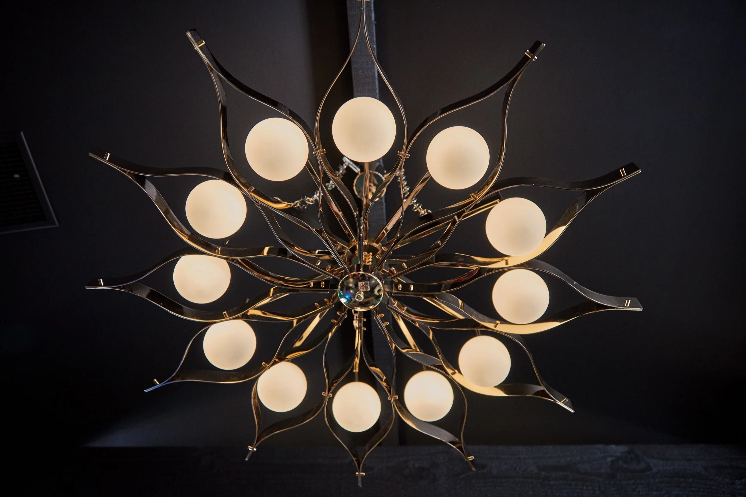 A starburst chandelier with glass globe lights.