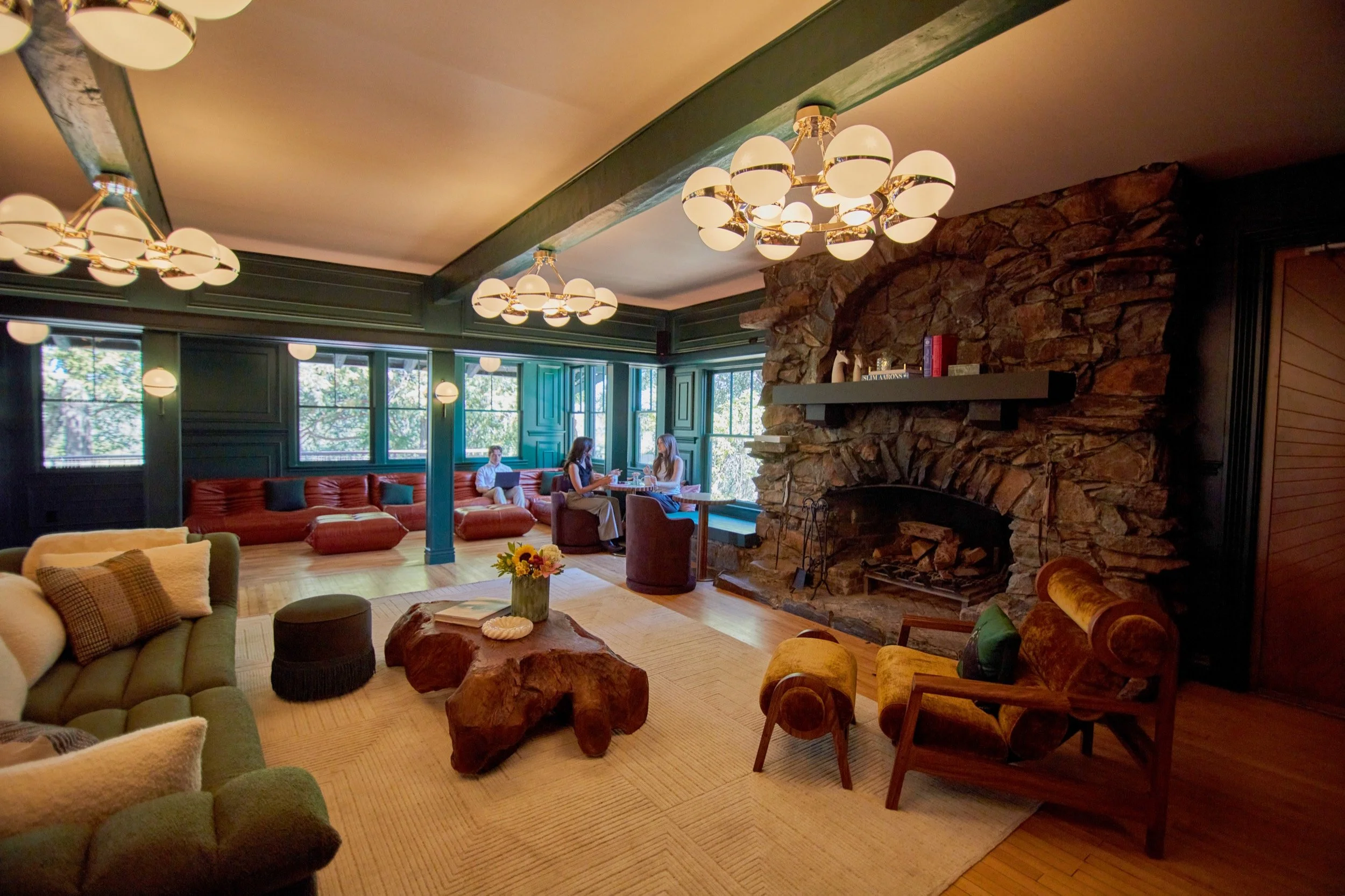 Lounge seating gathered around the stone fireplace in The Lodge lobby.