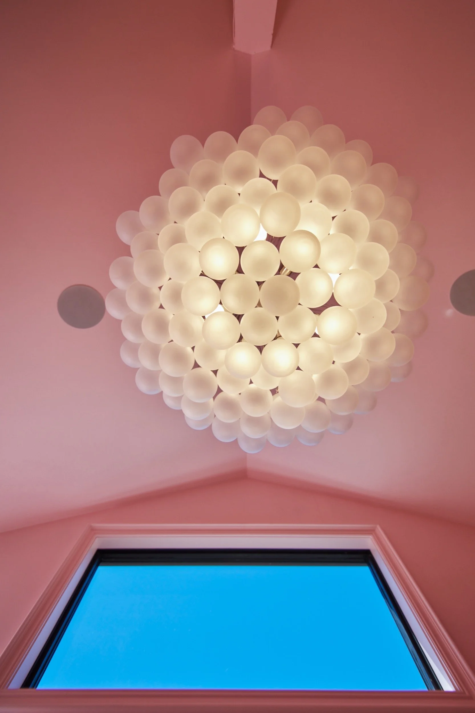 A glass globe chandelier on the Bridal Suite's pink vaulted ceiling.