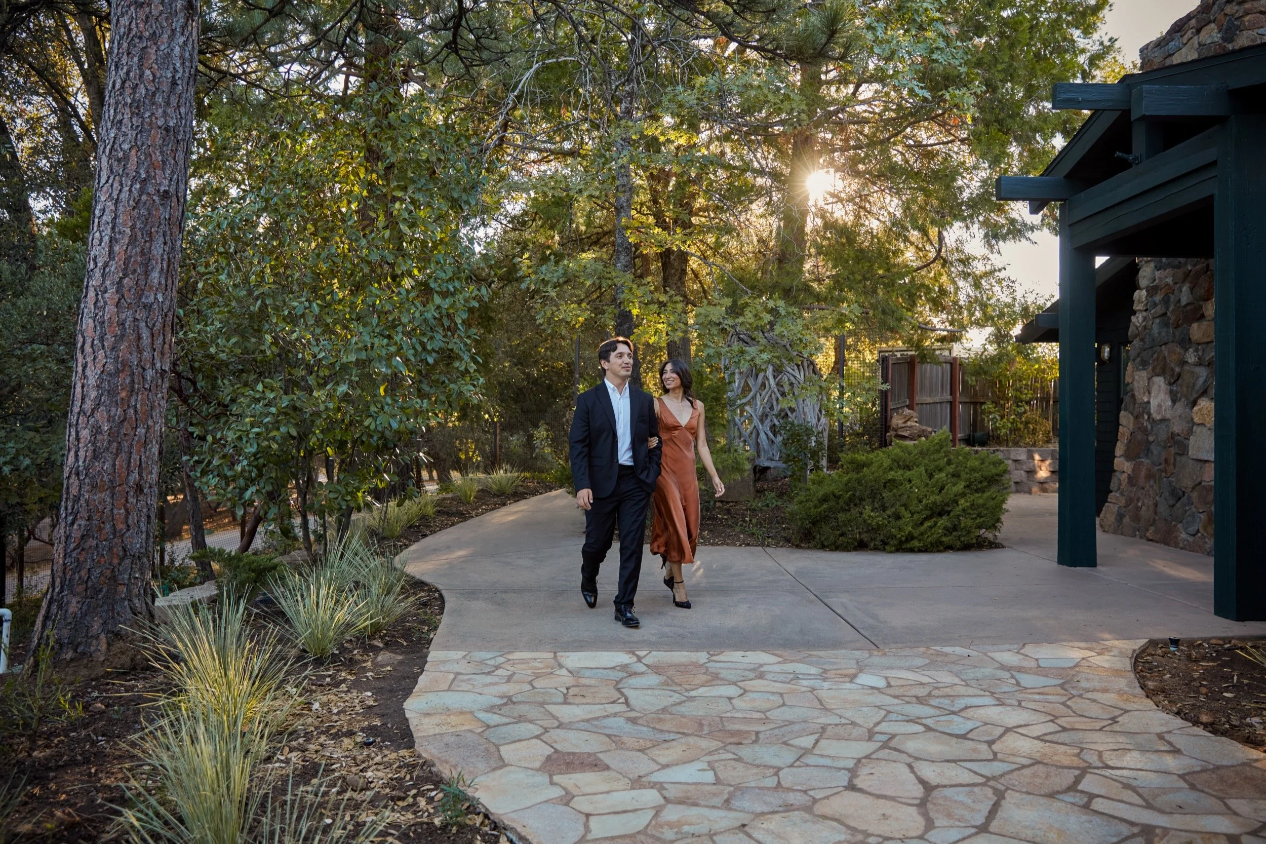 A couple walking the flagstone garden path at golden hour.