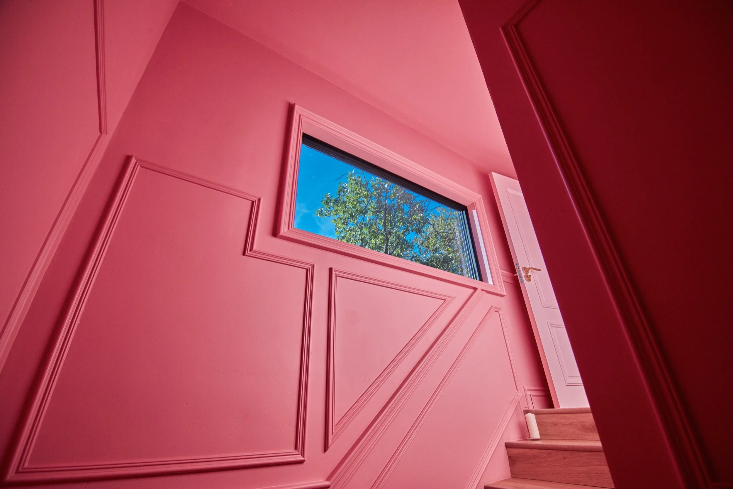 Pink paneled walls and a high window in the Bridal Suite stairwell.