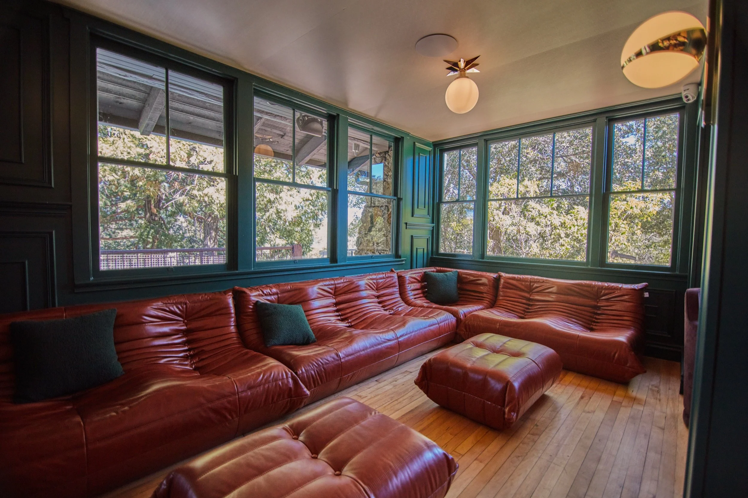 The Lodge Lobby with a leather sectional and windows onto the trees.