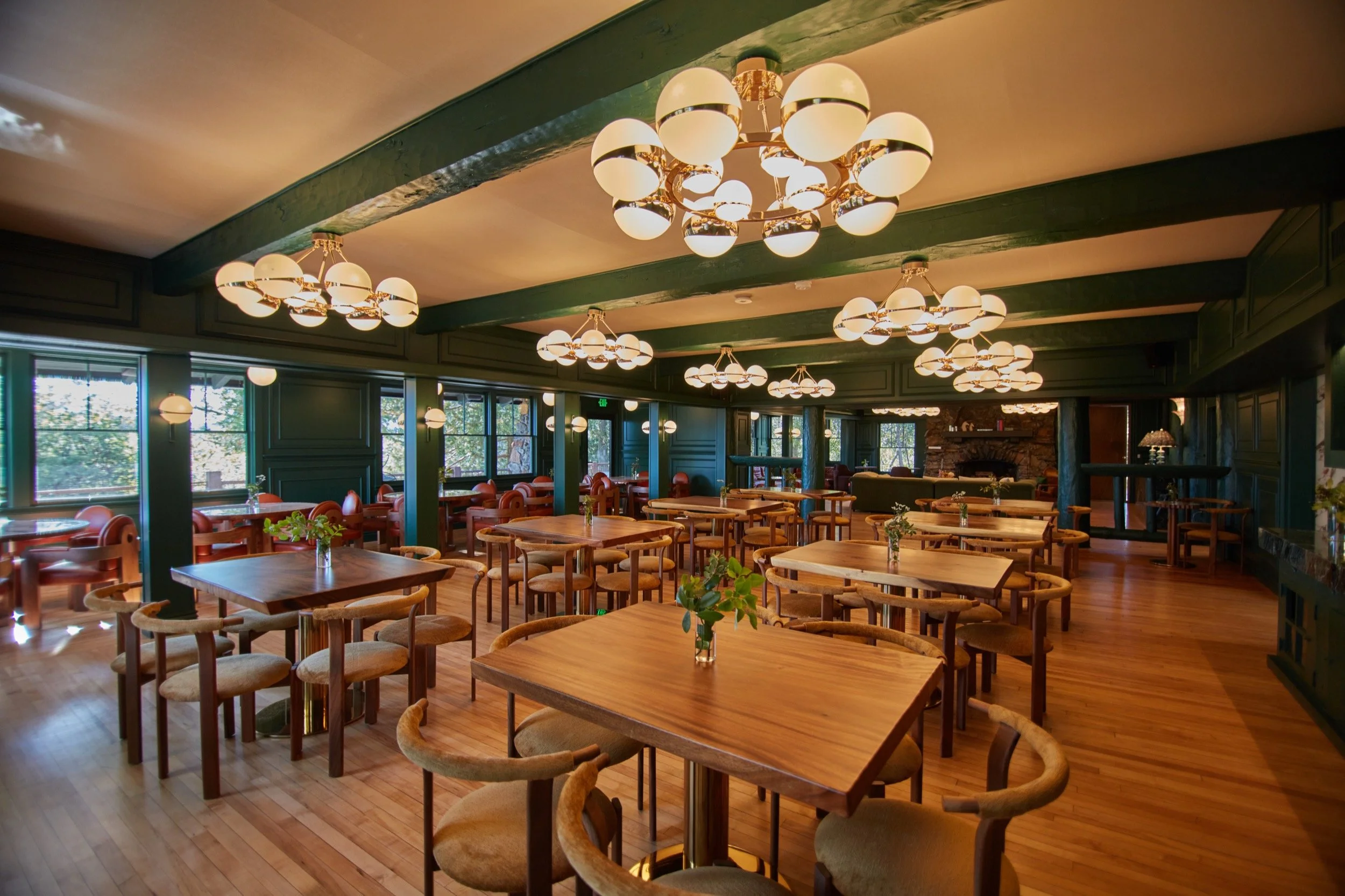 The Lodge dining room set with wood tables beneath globe chandeliers.