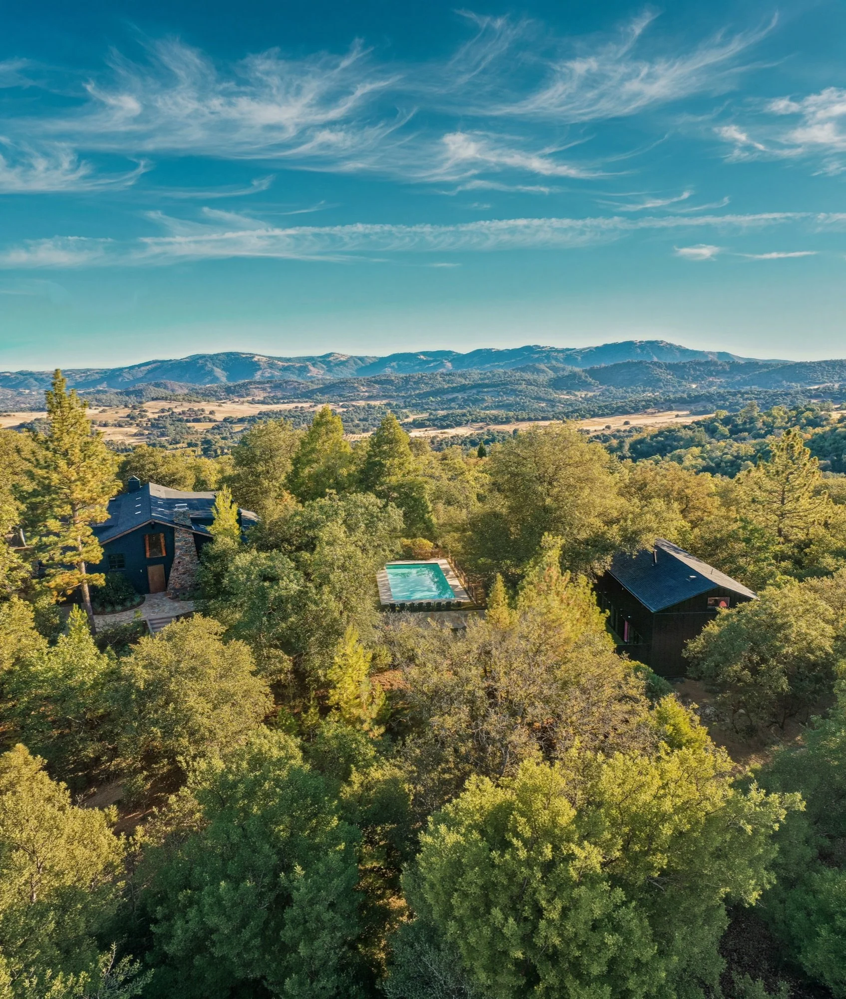 Aerial view of The Dempsey's eight wooded acres in Julian, with the pool and cabins tucked among the trees.