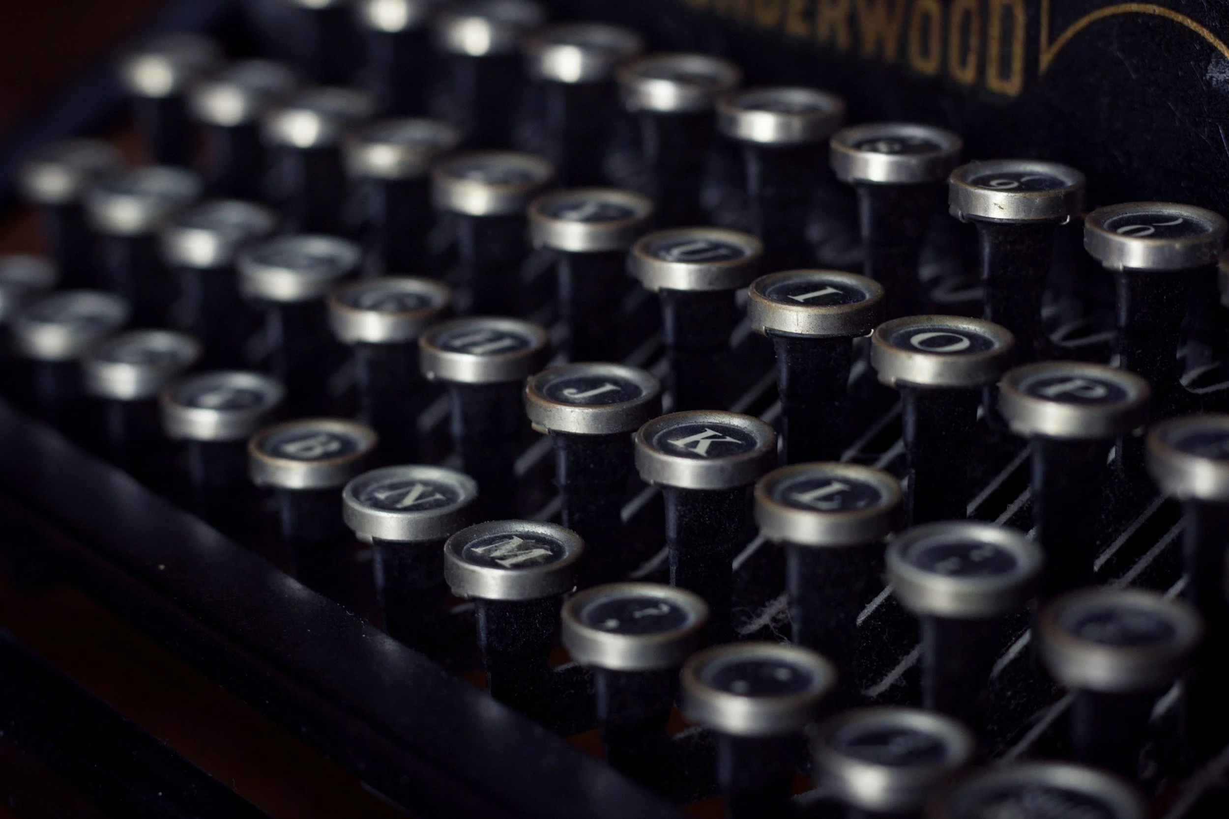 Close-up of vintage black and silver typewriter keys with numbers and letters.
