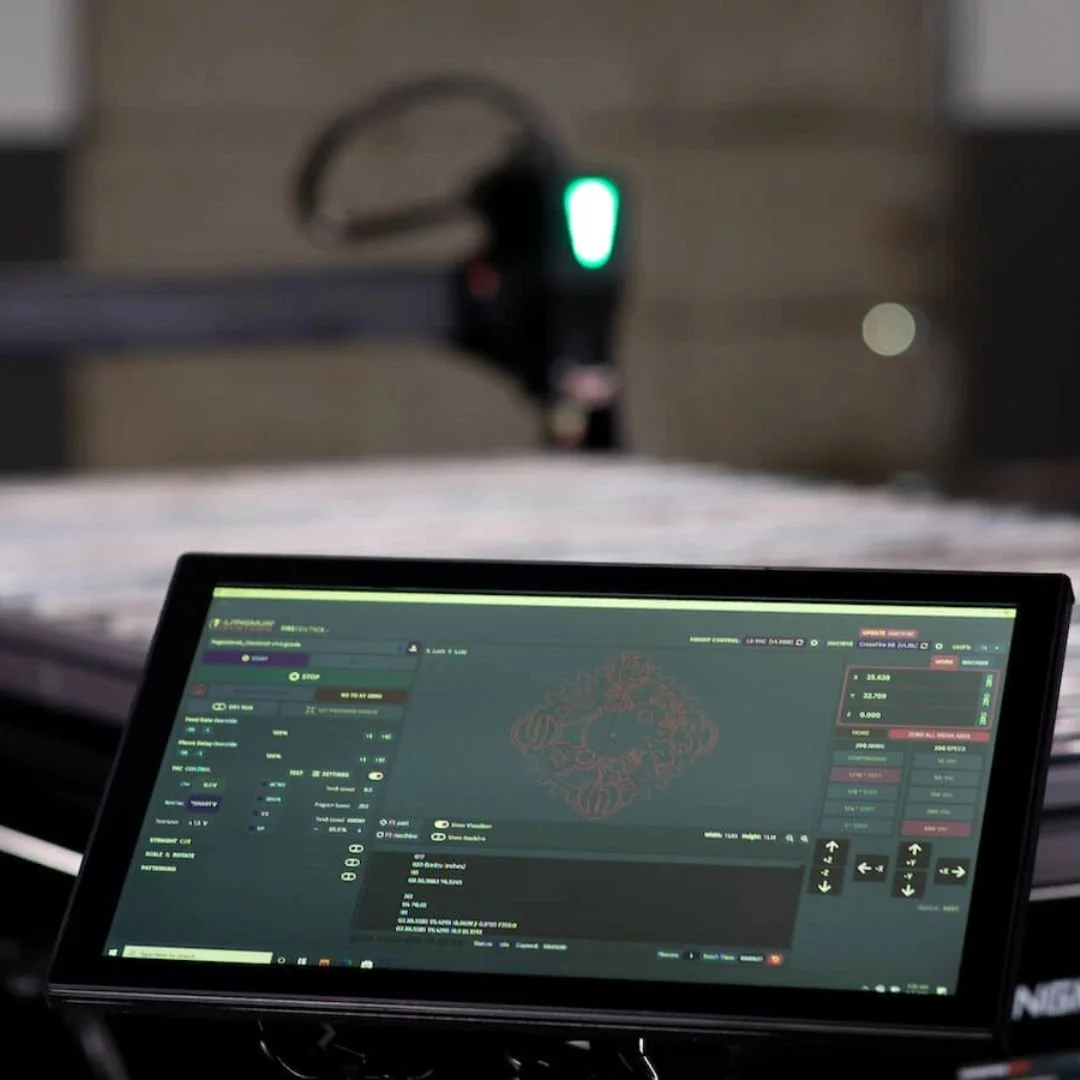 A computer screen displaying 3D modeling and design software, with a mystical or ornate pattern visible on the screen, and a 3D printer in the background with a green LED light.