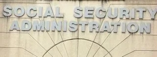 Sign reading 'Social Security Administration' on a building facade.