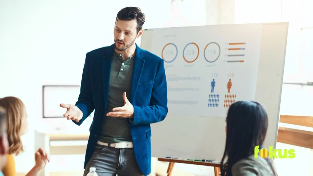 A man speaks to his colleagues about FōKUS Group's approach to building blended learning that enhances performance.