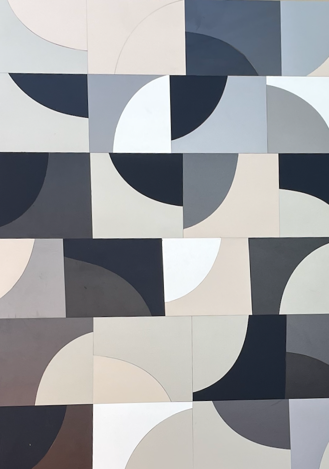 Wall with geometric pattern of squares and semi-circles in shades of black, white, gray, and beige.