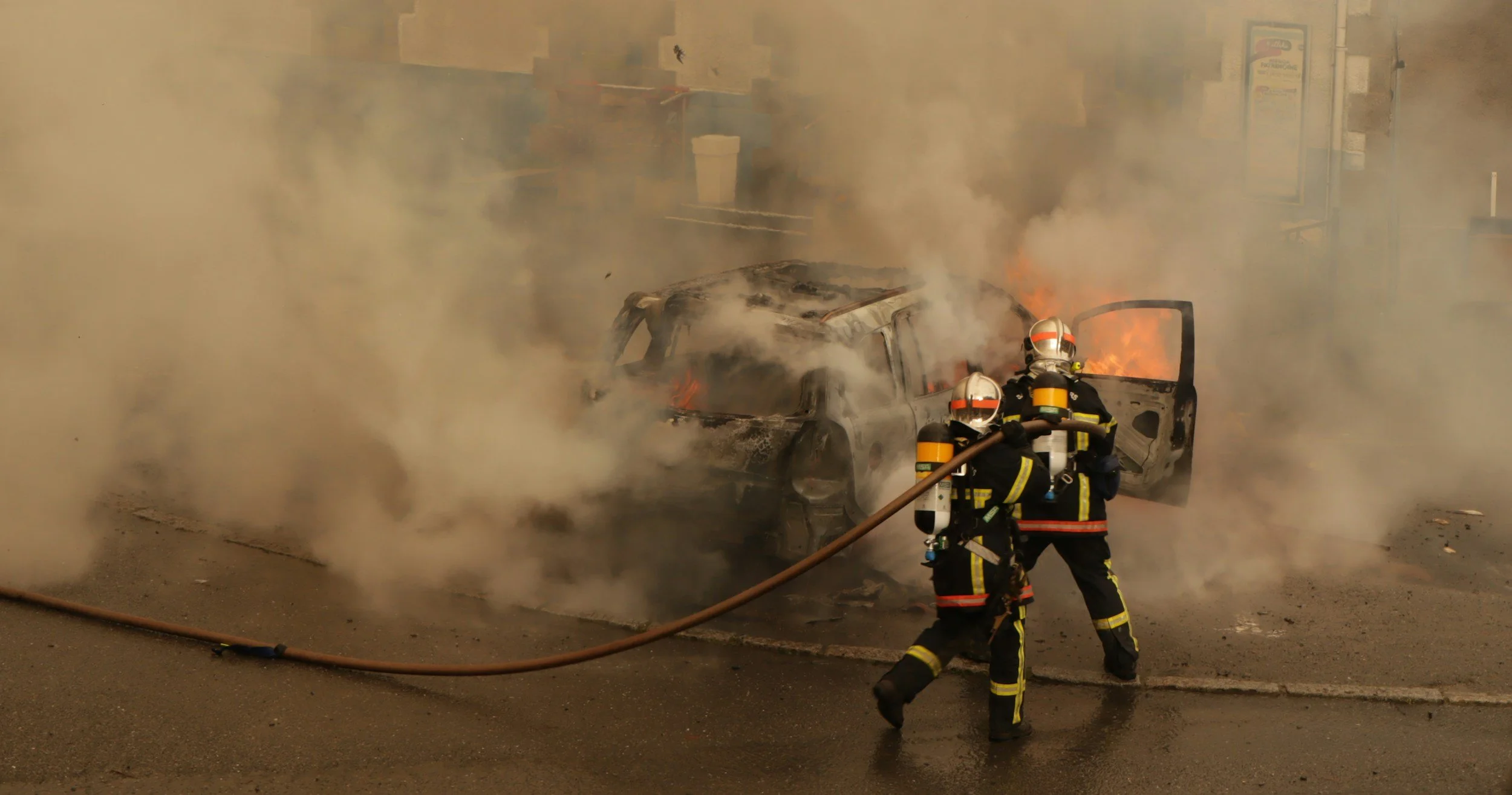 firefighters putting out a burning car