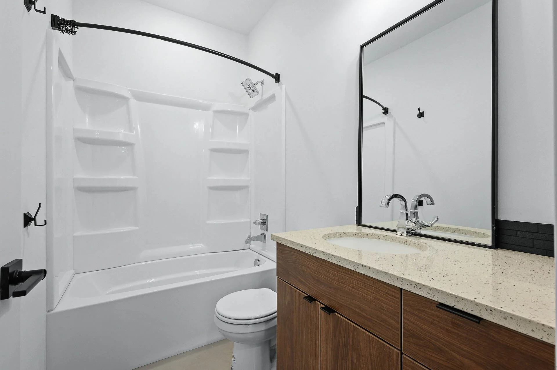 Bathroom with bathtub, shower, toilet, wooden vanity, and large mirror.