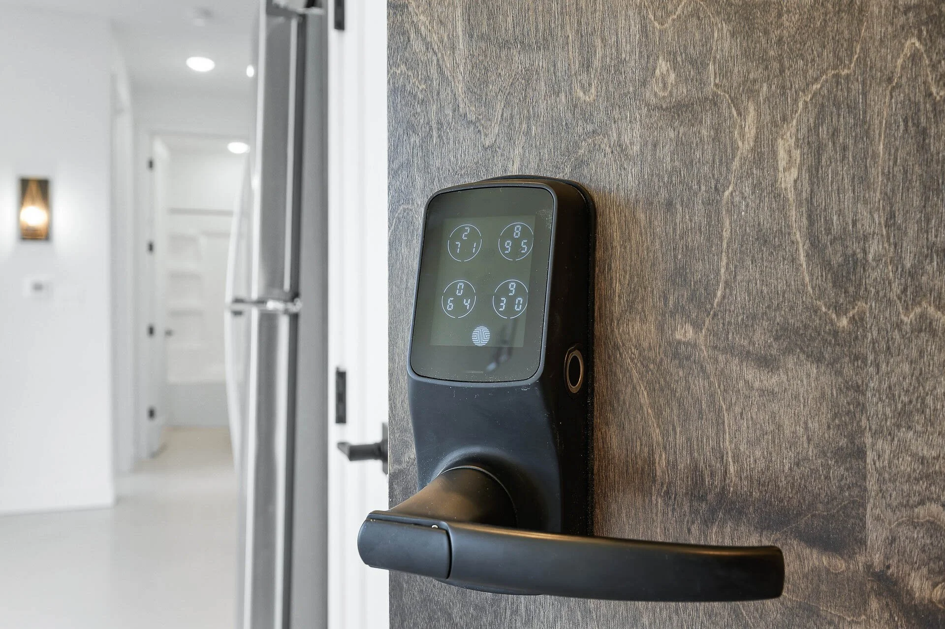 Electronic door lock with digital keypad display installed on a door.